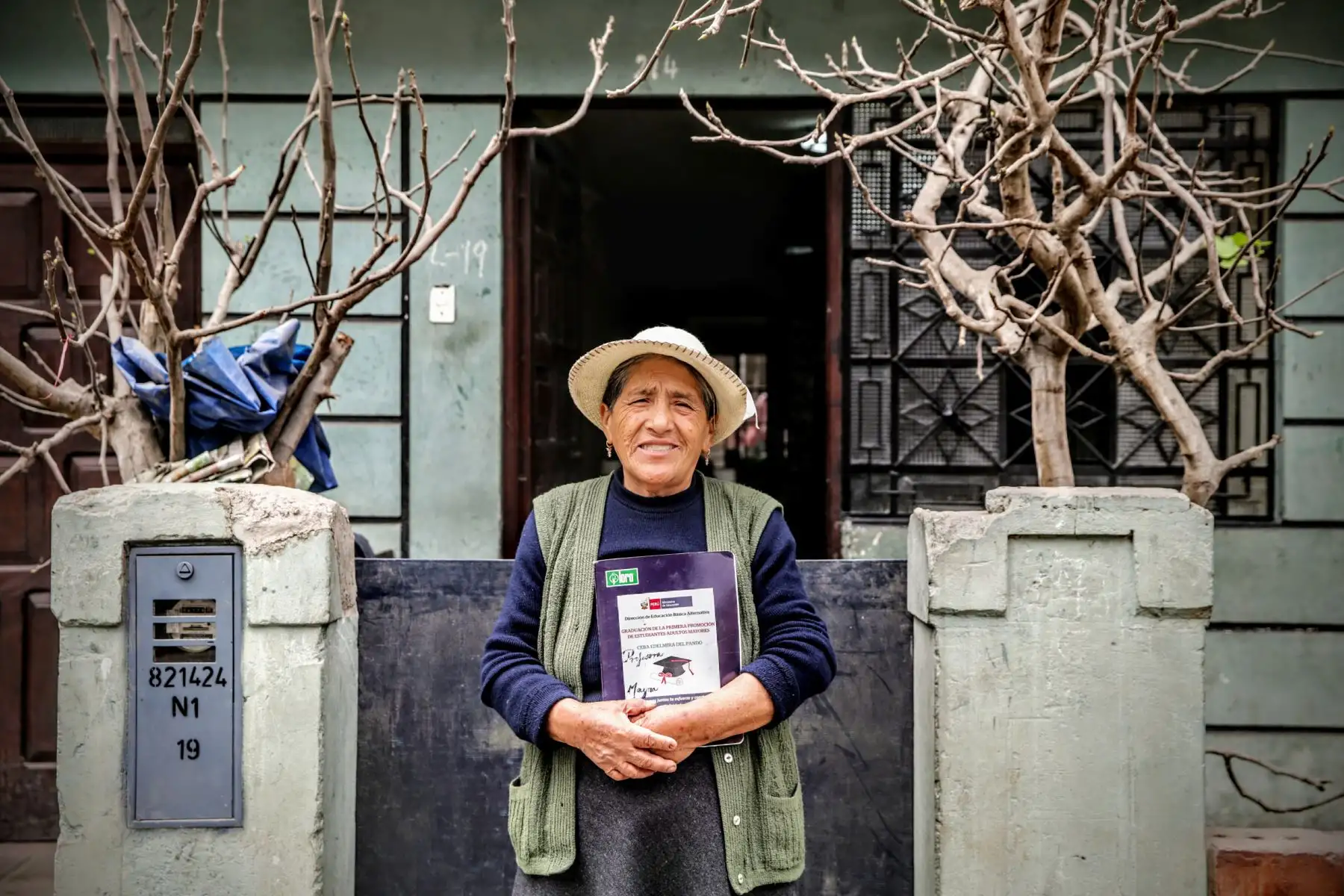 Casilda posa frente a la casa que construyó su esposo poco a poco a lo largo de muchos años. Foto: ANDINA/Luis Iparraguirre
