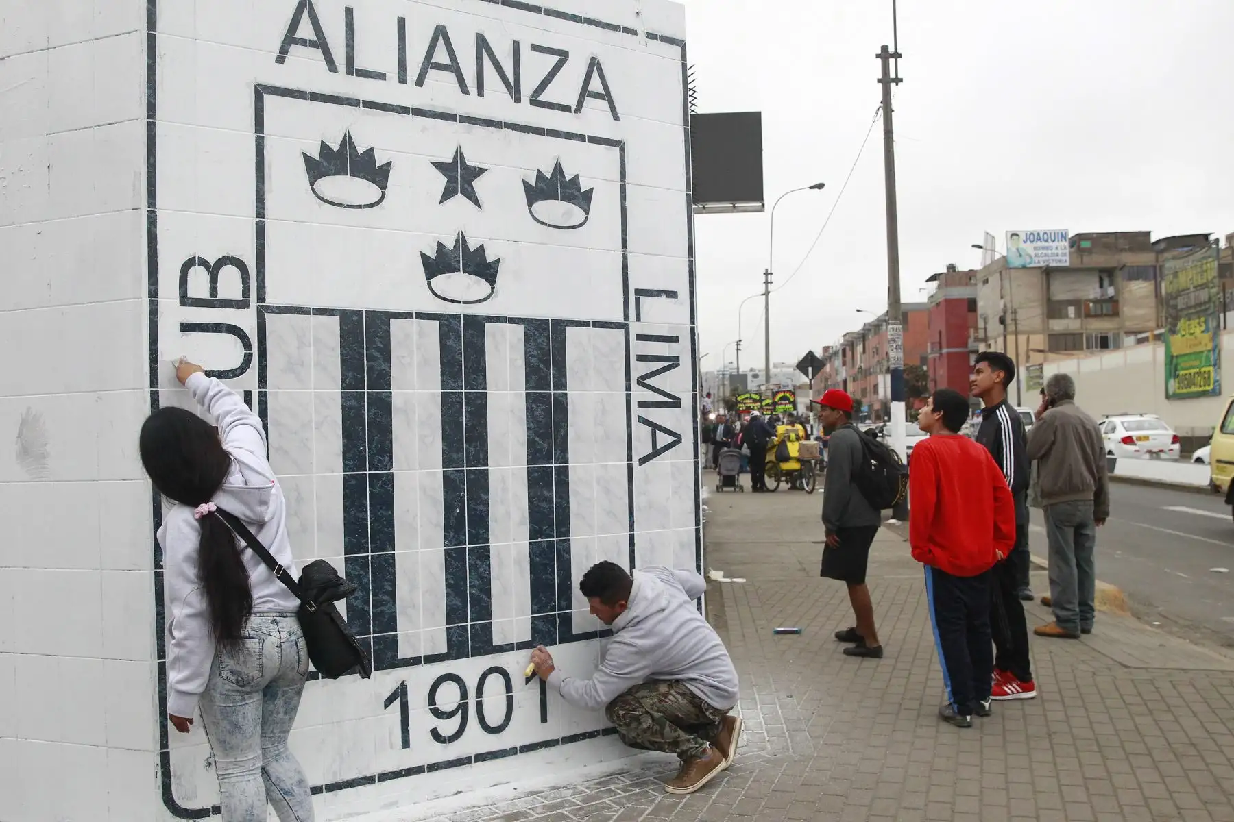 Hinchas blanquiazules limpian los murales dañados  tras incidente en la explanada del  estadio de Alianza Lima.Foto: ANDINA/Eddy Ramos