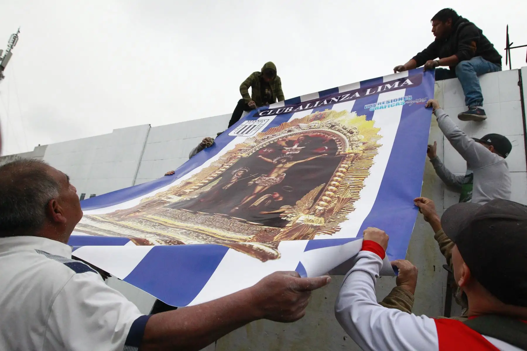 Hinchas blanquiazules colocan una gigantografía de la imagen del Señor de los Milagros en los exteriores de la explanada del  estadio de Alianza Lima.Foto: ANDINA/Eddy Ramos