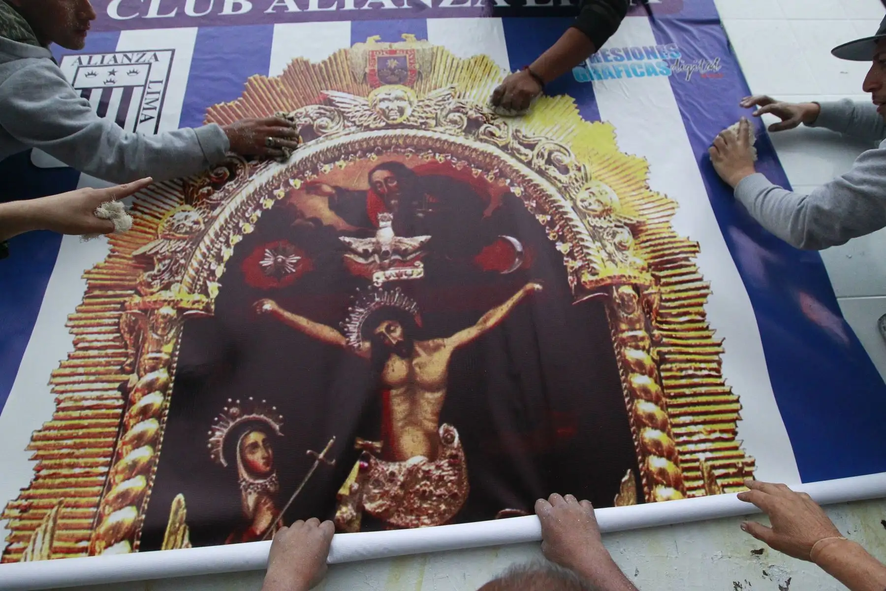Hinchas blanquiazules colocan una gigantografía de la imagen del Señor de los Milagros en los exteriores de la explanada del  estadio de Alianza Lima.Foto: ANDINA/Eddy Ramos