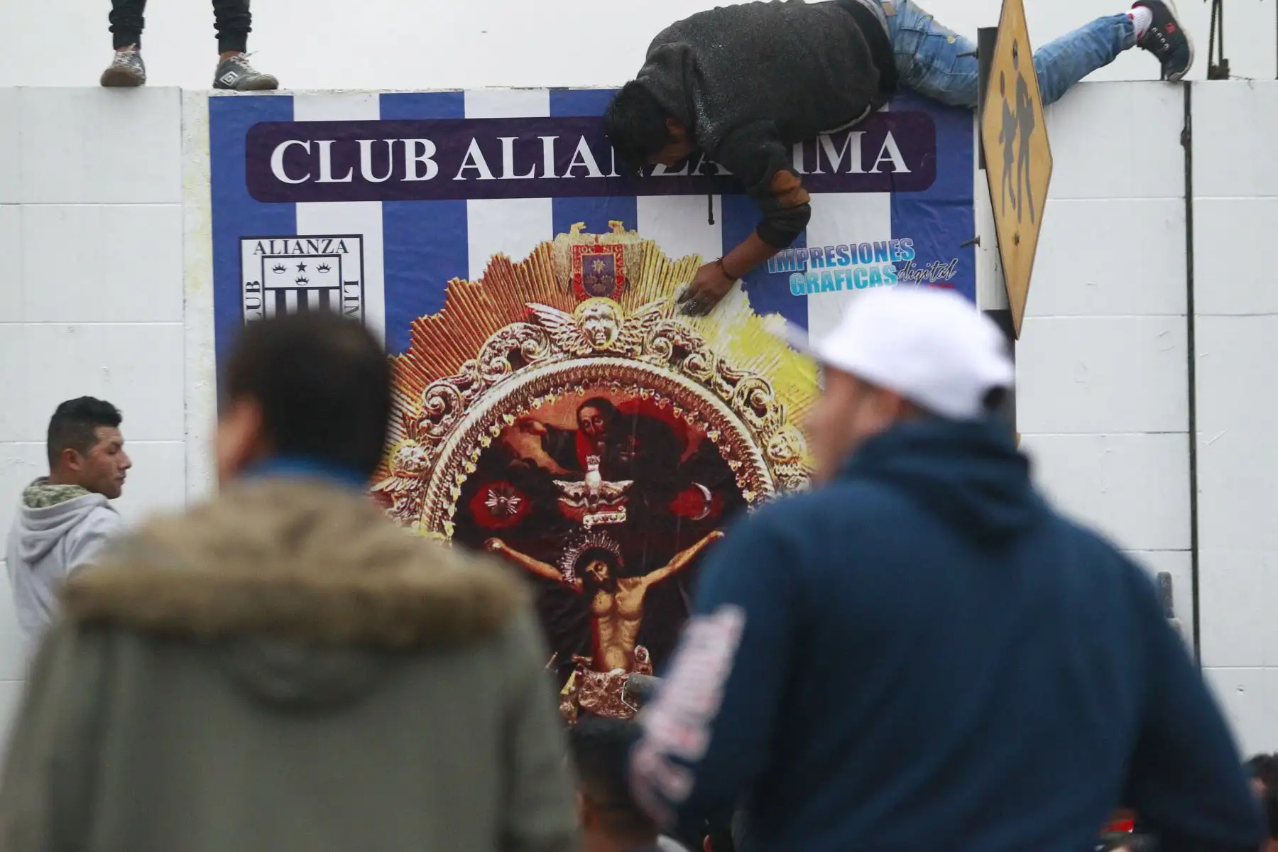 Hinchas blanquiazules colocan una gigantografía de la imagen del Señor de los Milagros en los exteriores de la explanada del  estadio de Alianza Lima.Foto: ANDINA/Eddy Ramos