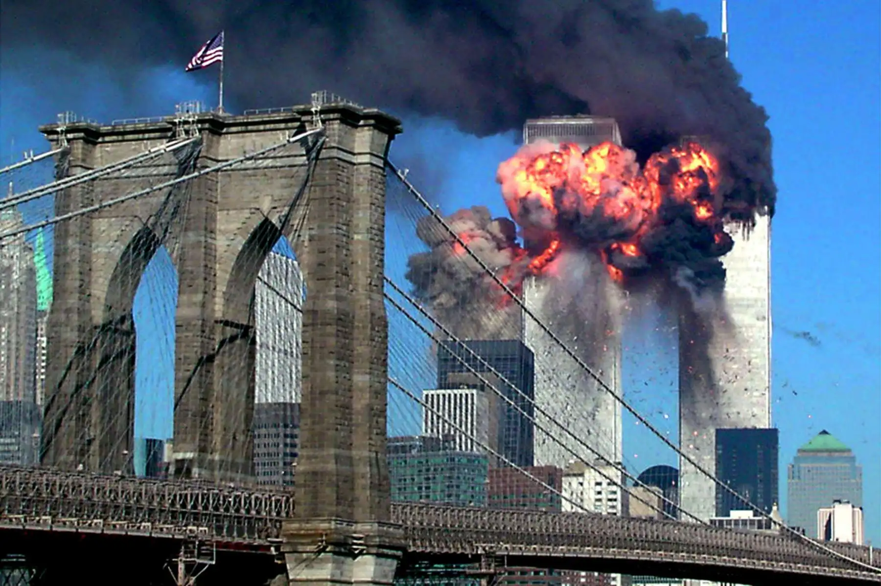 Con el puente de Brooklyn en primer plano, un avión explota después de golpear la segunda torre del World Trade Center mientras la otra torre se quema. Nueva York,  11 de septiembre de 2001. Foto: REUTERS