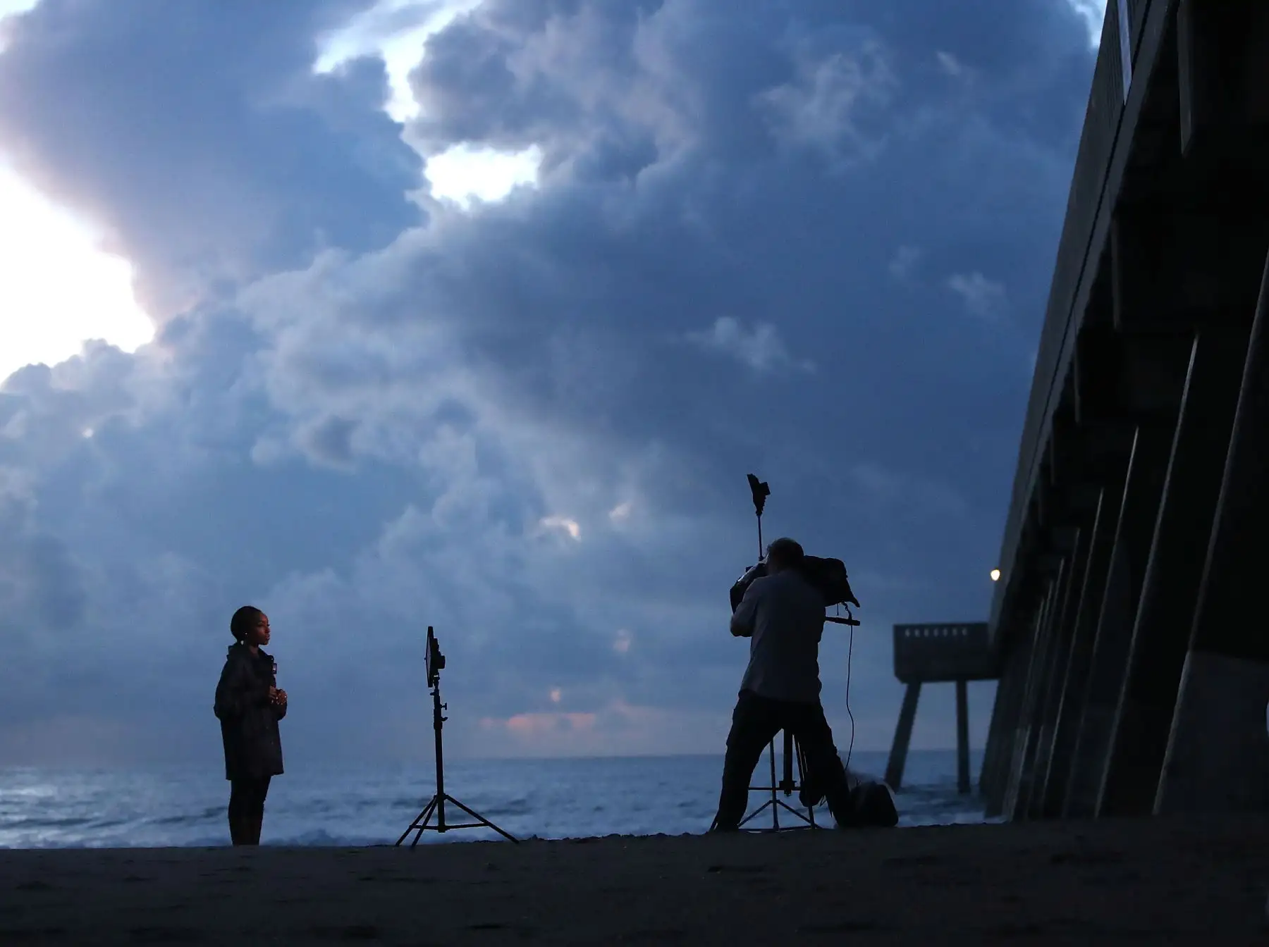 Los miembros de los medios informan desde Wrightsville Beach Pier antes de la llegada prevista del huracán Florence el 12 de septiembre de 2018 en Wrightsville Beach, Estados Unidos. El huracán Florence se espera el viernes posiblemente como una tormenta de categoría 4 a lo largo de la costa de Virginia, Carolina del Norte y Carolina del Sur. AFP