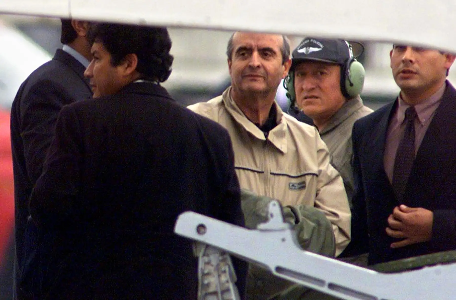 Miembros de la policía peruana custodian al ex asesor presidencial Vladimiro Montesinos  el 25 de junio de 2001 en Lima después de su deportación de Venezuela. Montesinos fue arrestado el 24 de junio en Caracas por miembros de la inteligencia militar de Venezuela luego de permanecer ocho meses en la clandestinidad.  Montesinos era buscado por tráfico de armas, violaciones de los derechos humanos, corrupción y otros cargos. Foto: AFP