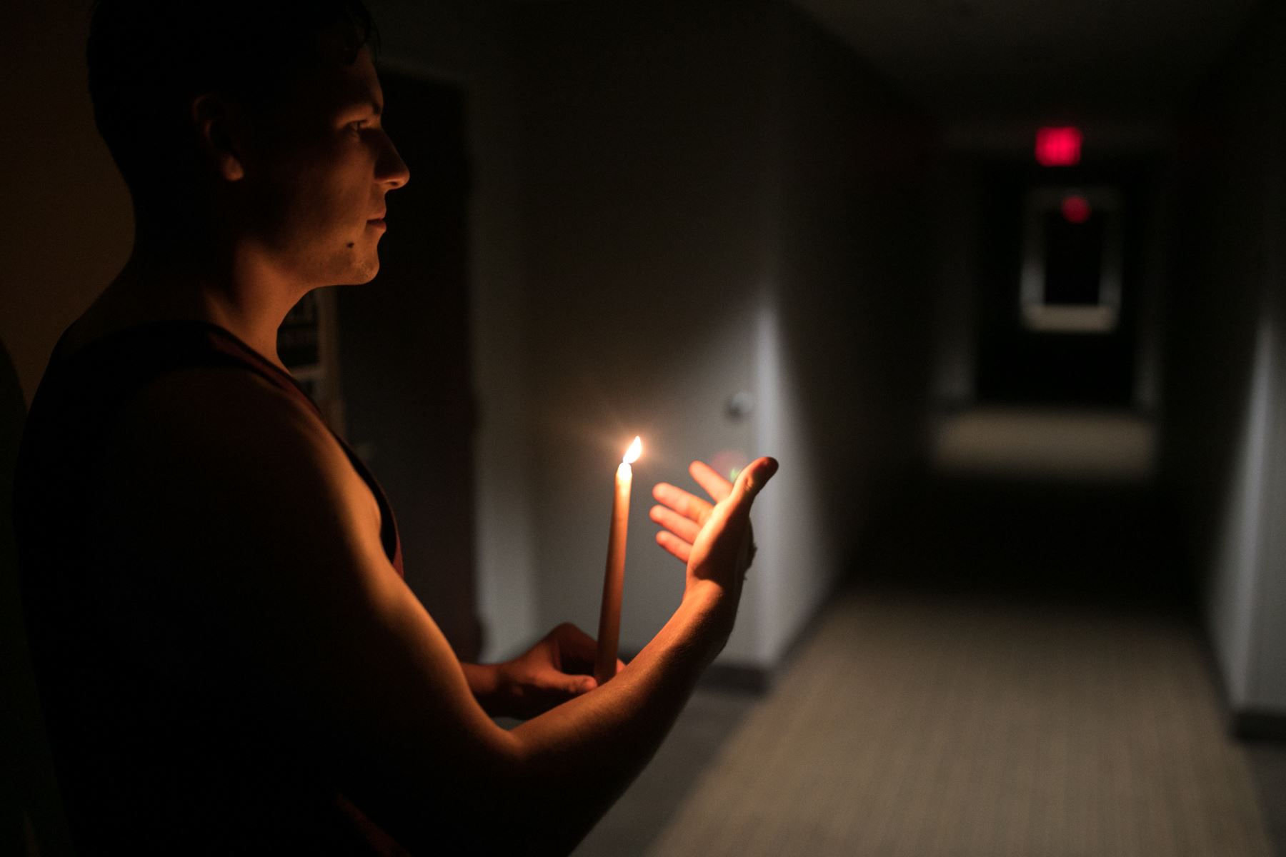 Richardson Tumulak trae una vela a una habitación para parejas mayores después del hotel Sleep Inn en el que se quedaron sin electricidad, durante el huracán Florence.. / AFP