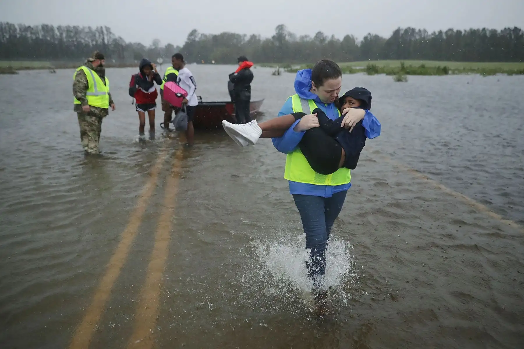 Voluntarios del Equipo Civil de Respuesta a Crisis ayudan a rescatar a tres niños de su hogar inundado el 14 de septiembre de 2018 en James City, Estados Unidos. El huracán Florence tocó tierra en Carolina del Norte como una tormenta de Categoría 1 y las inundaciones causadas por las fuertes lluvias obligan a cientos de personas a pedir rescates de emergencia en el área alrededor de New Bern, Carolina del Norte, que se encuentra en la confluencia de los ríos Nueces y Trent. AFP