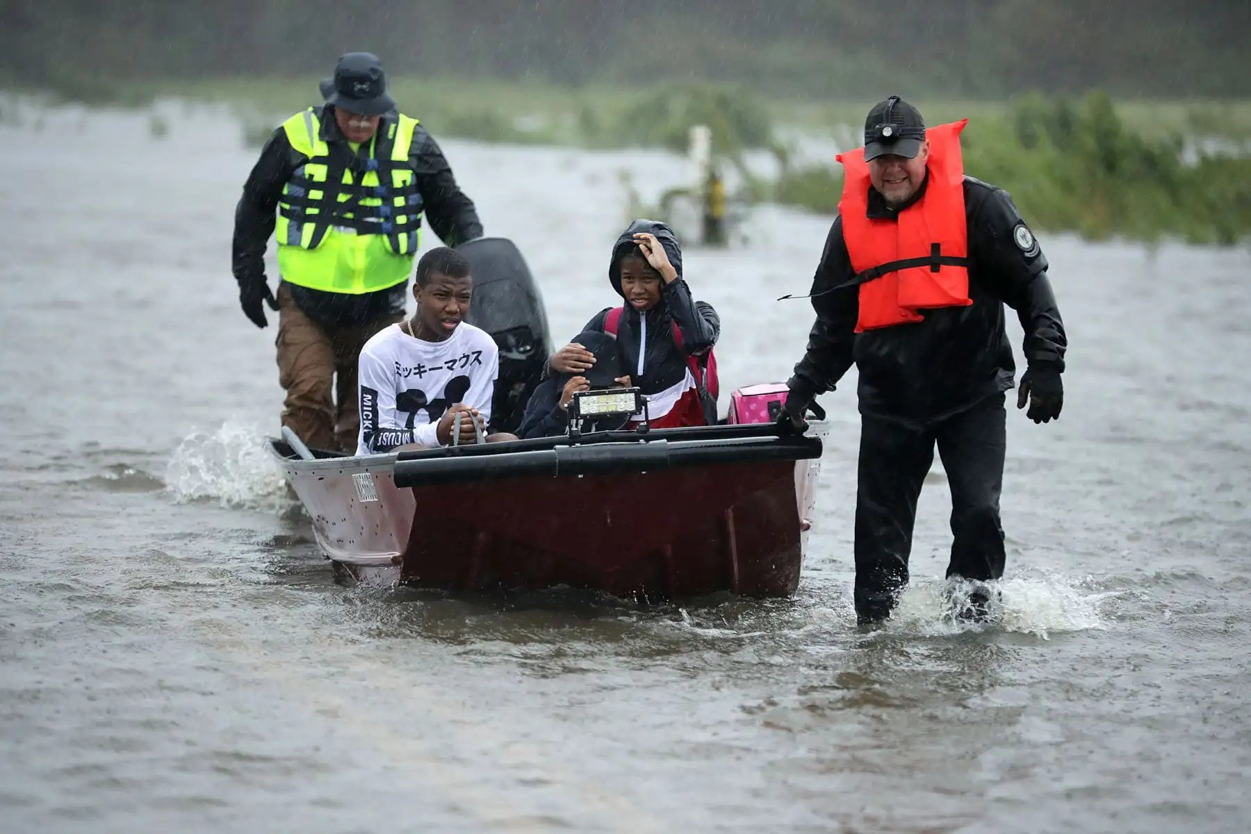Voluntarios del Equipo Civil de Respuesta a Crisis ayudan a rescatar a tres niños de su hogar inundado el 14 de septiembre de 2018 en James City, Estados Unidos. El huracán Florence tocó tierra en Carolina del Norte como una tormenta de Categoría 1 y las inundaciones causadas por las fuertes lluvias obligan a cientos de personas a pedir rescates de emergencia en el área alrededor de New Bern, Carolina del Norte, que se encuentra en la confluencia de los ríos Nueces y Trent.  AFP