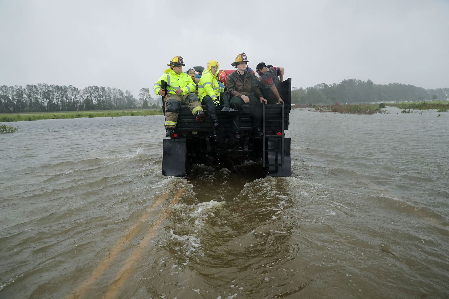 los trabajadores de rescate del Departamento de Bomberos N º 7 y voluntarios del Equipo de Respuesta de Crisis Civil utilizan un camión para mover a las personas rescatadas de sus casas inundadas durante el huracán Florencia 14 de septiembre de 2018 en James City, Estados Unidos. El huracán Florence tocó tierra en Carolina del Norte como una tormenta de Categoría 1 y las inundaciones causadas por las fuertes lluvias obligan a cientos de personas a pedir rescates de emergencia en el área alrededor de New Ber