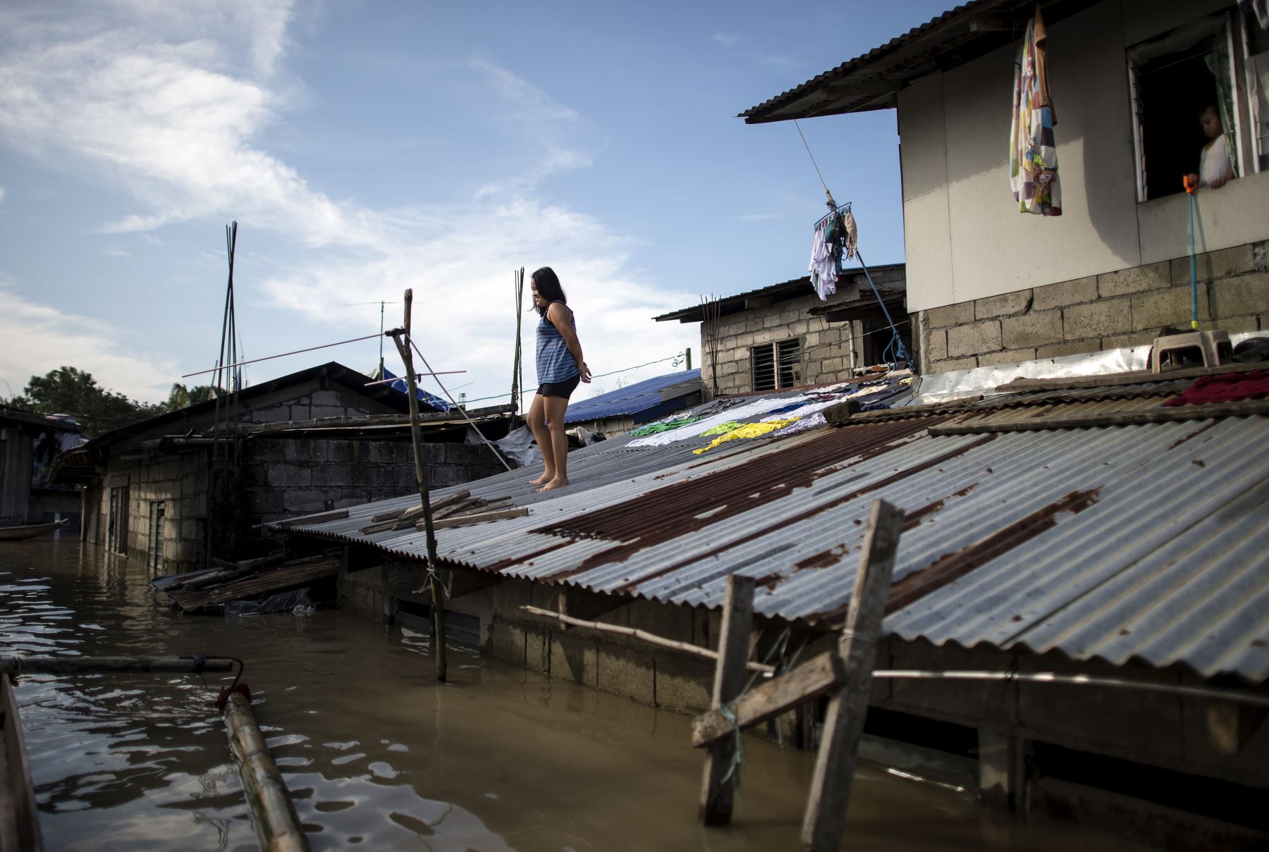 Una mujer mira desde el techo de su casa sobre las aguas de las inundaciones luego del Súper Tifón Mangkhut en Calumpit, Bulacan el 17 de septiembre de 2018.
Hong Kong comenzó una limpieza masiva el 17 de septiembre después de que el tifón Mangkhut barrió la ciudad, destrozó árboles y provocó inundaciones dañinas en un camino de destrucción que dejó decenas de muertos en Filipinas y millones de evacuados en el sur de China.
  AFP