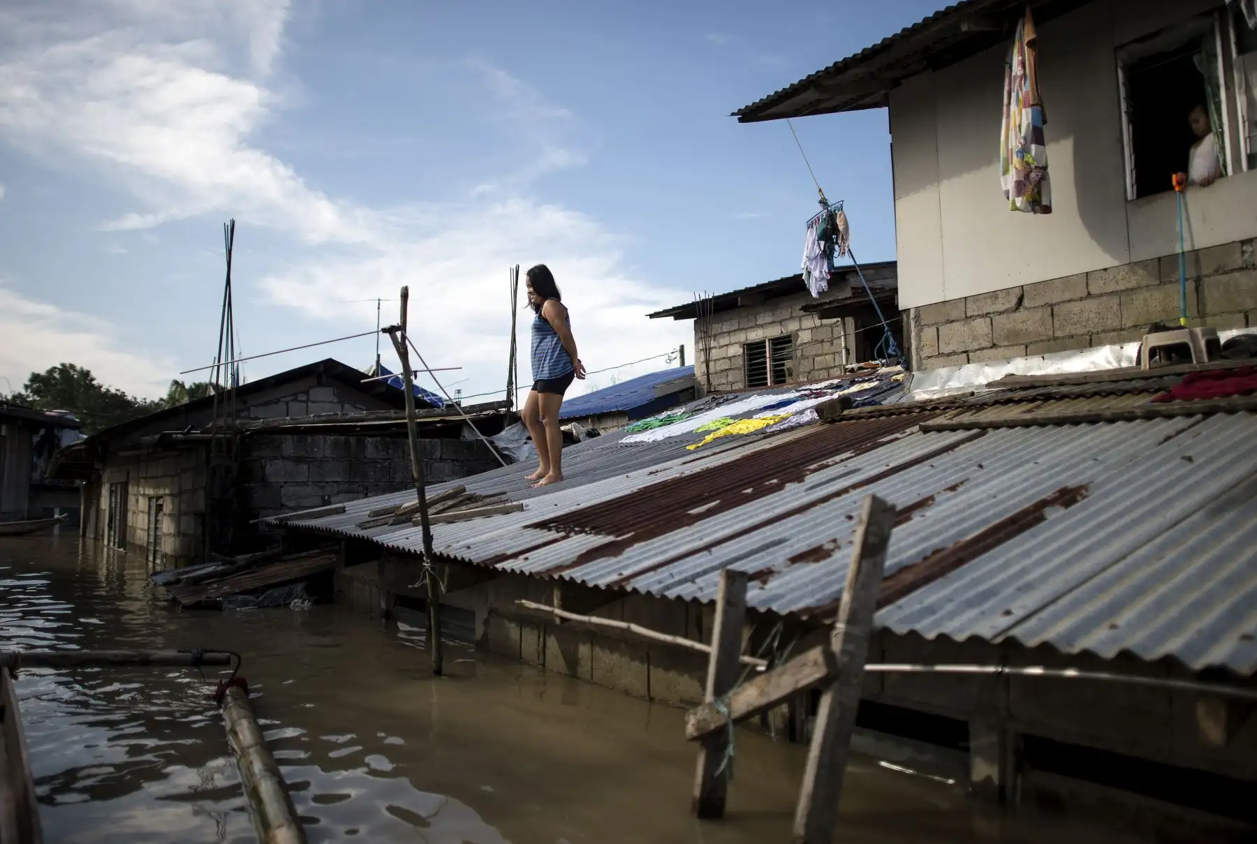Una mujer mira desde el techo de su casa sobre las aguas de las inundaciones luego del Súper Tifón Mangkhut en Calumpit, Bulacan el 17 de septiembre de 2018.
Hong Kong comenzó una limpieza masiva el 17 de septiembre después de que el tifón Mangkhut barrió la ciudad, destrozó árboles y provocó inundaciones dañinas en un camino de destrucción que dejó decenas de muertos en Filipinas y millones de evacuados en el sur de China.
  AFP