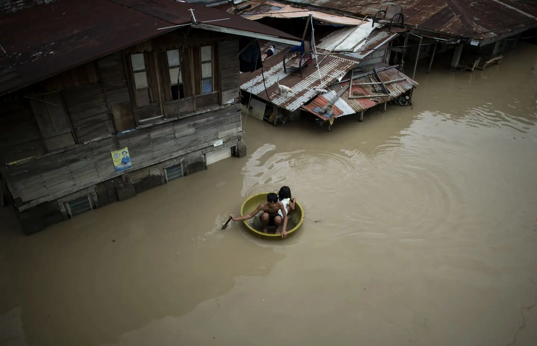 Los niños usan un lavabo para cruzar una calle inundada después del Súper Tifón Mangkhut en Salonga Compound en Calumpit, Bulacan.  AFP