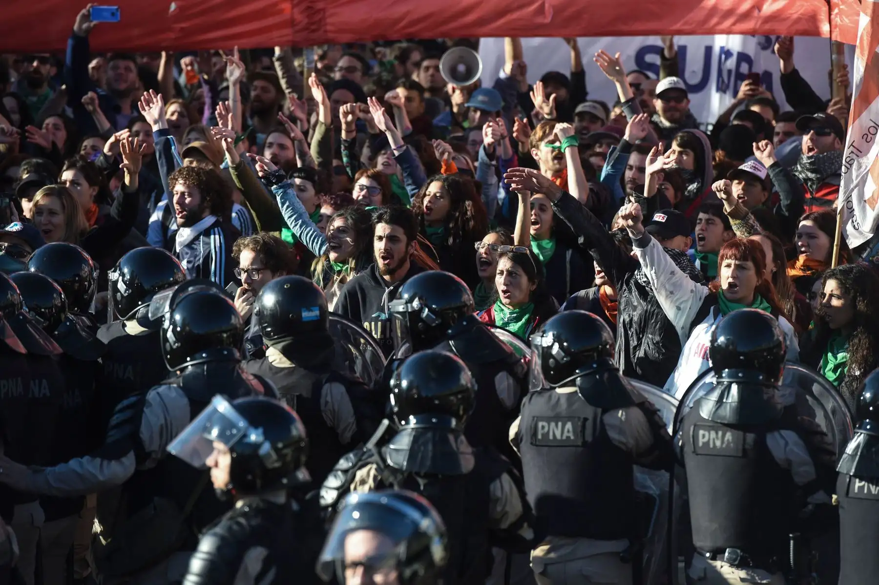 Miembros de la Prefectura Naval Argentina (PNA), tratan de evitar que los manifestantes bloqueen el puente Pueyrredon en Buenos Aires Foto: AFP