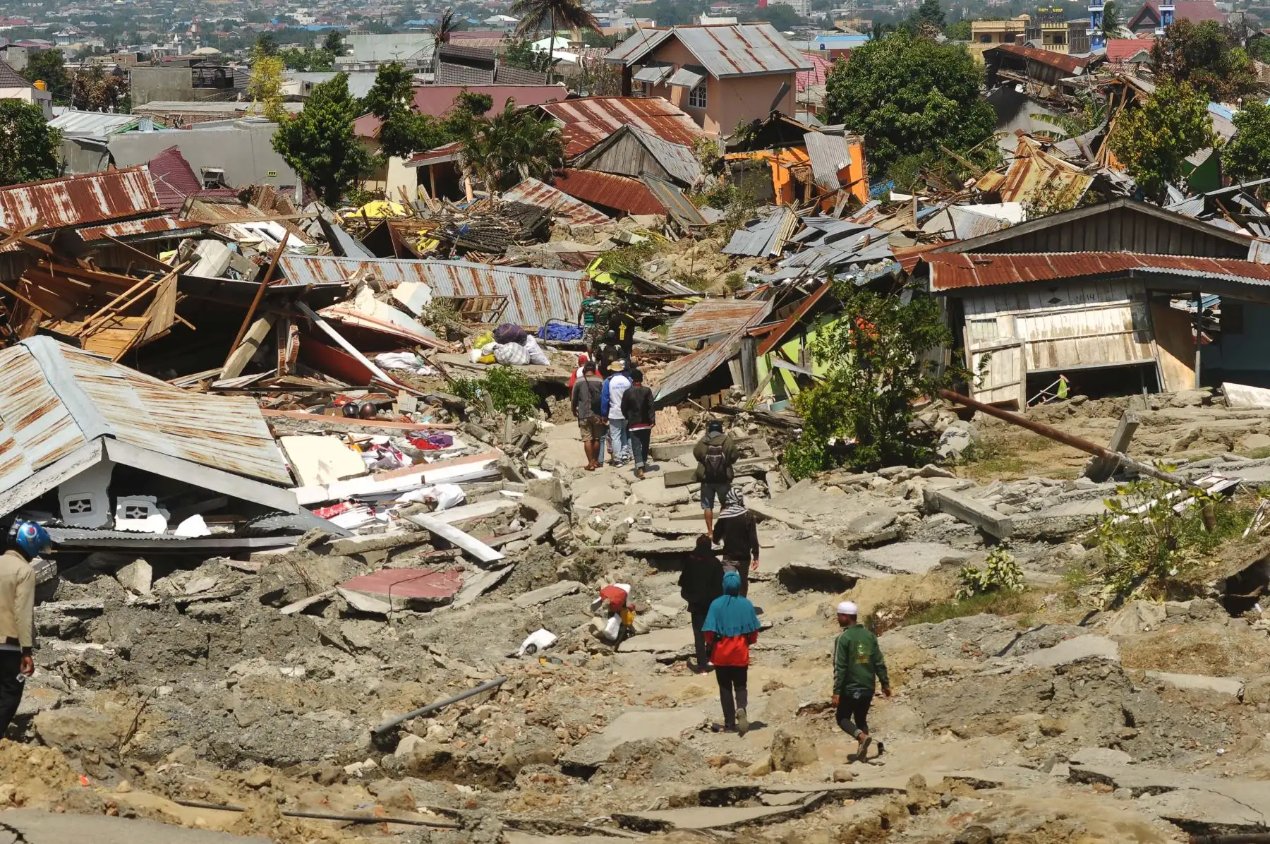 Los residentes regresan a sus casas colapsadas para rescatar sus pertenencias en Palu, Célebes Central de Indonesia, el 1 de octubre de 2018, después de que un terremoto y un tsunami azotaran la zona. AFP