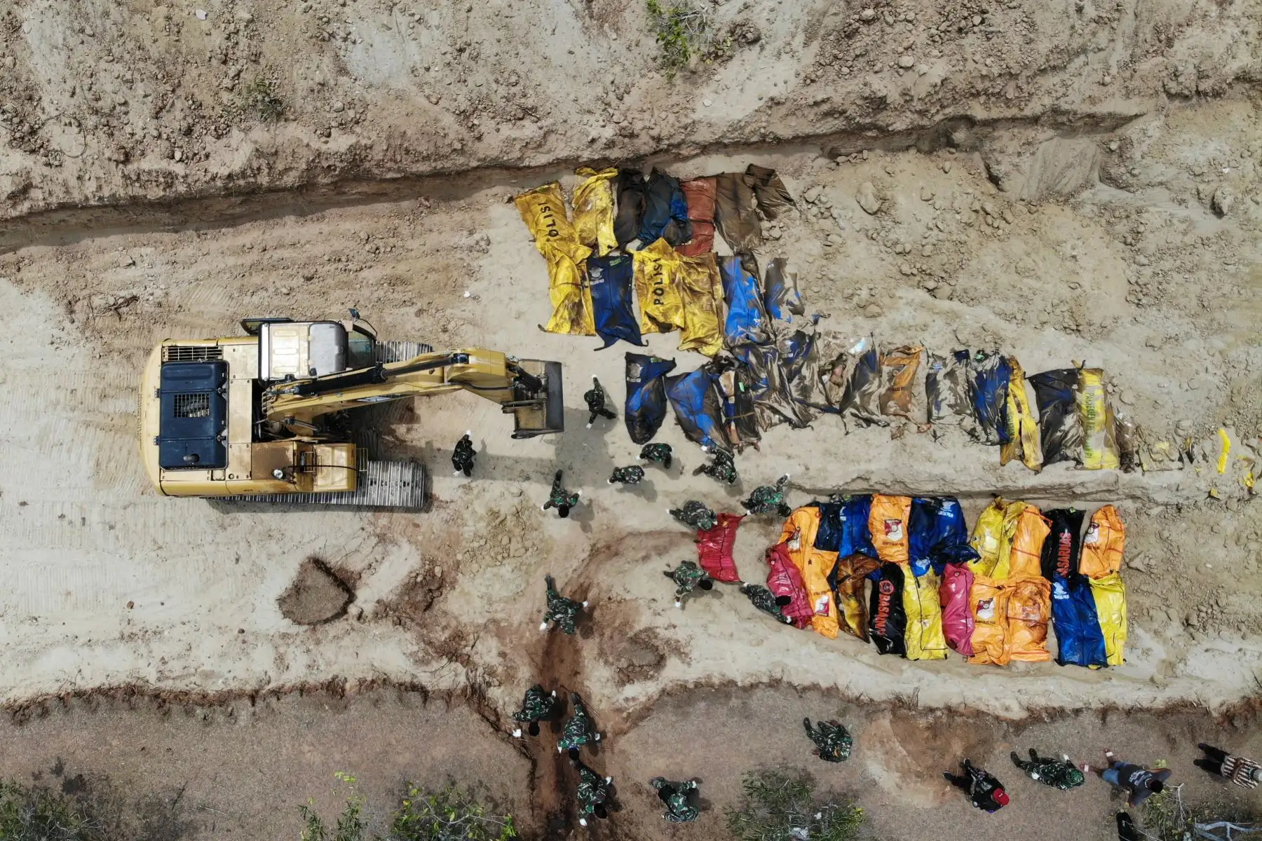 Esta fotografía aérea muestra a los soldados indonesios enterrando a las víctimas del terremoto en una fosa común en Poboya en Sulawesi Central de Indonesia el 2 de octubre de 2018, después de que un terremoto y un tsunami azotaron el área el 28 de septiembre.
El 2 de octubre, el gobierno de Indonesia dijo que la cifra de muertos en un devastador terremoto-tsunami en la isla de Sulawesi había aumentado a 1.234 personas, más que el recuento anterior de 844. / AFP