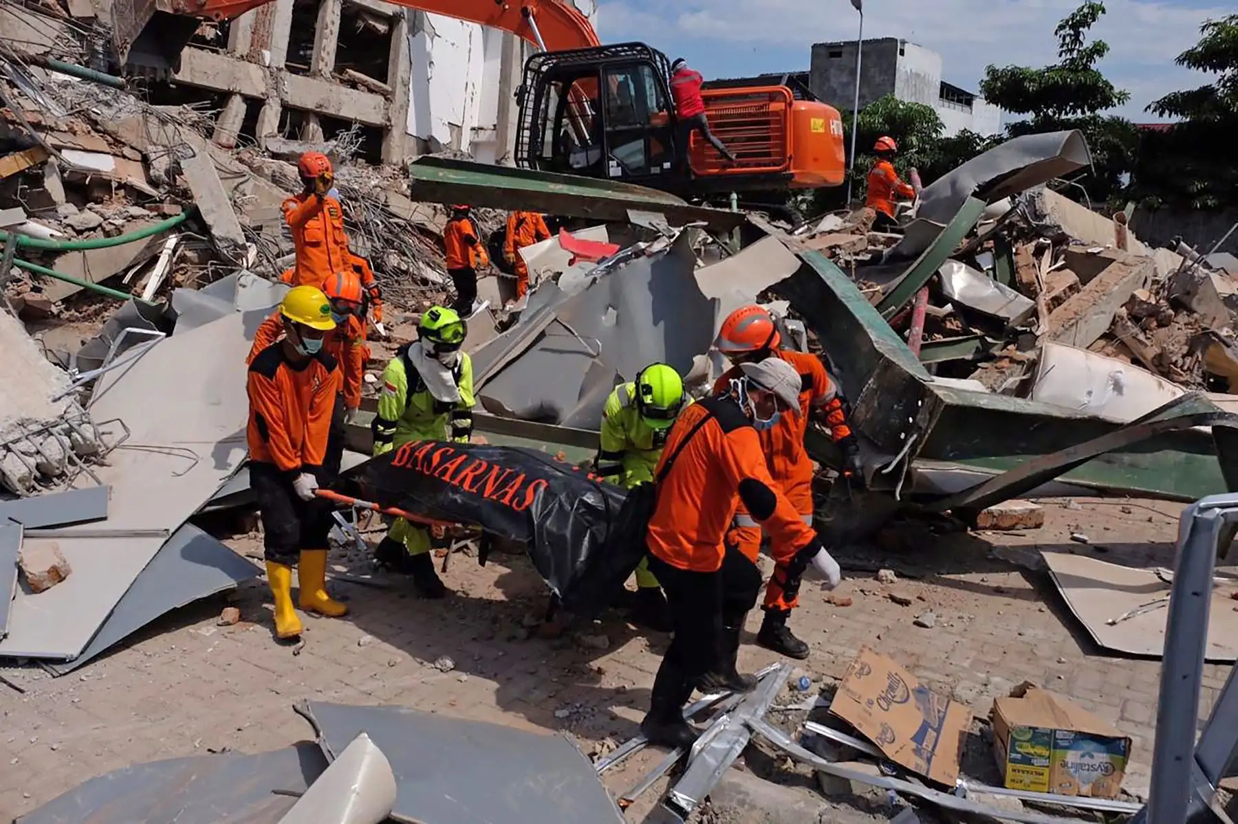 Los miembros de un equipo de rescate indonesio retiran el cuerpo de una víctima del terremoto recuperada de un edificio derrumbado en Palu en Sulawesi Central el 2 de octubre de 2018, después de que un terremoto y un tsunami azotaron el área el 28 de septiembre. AFP