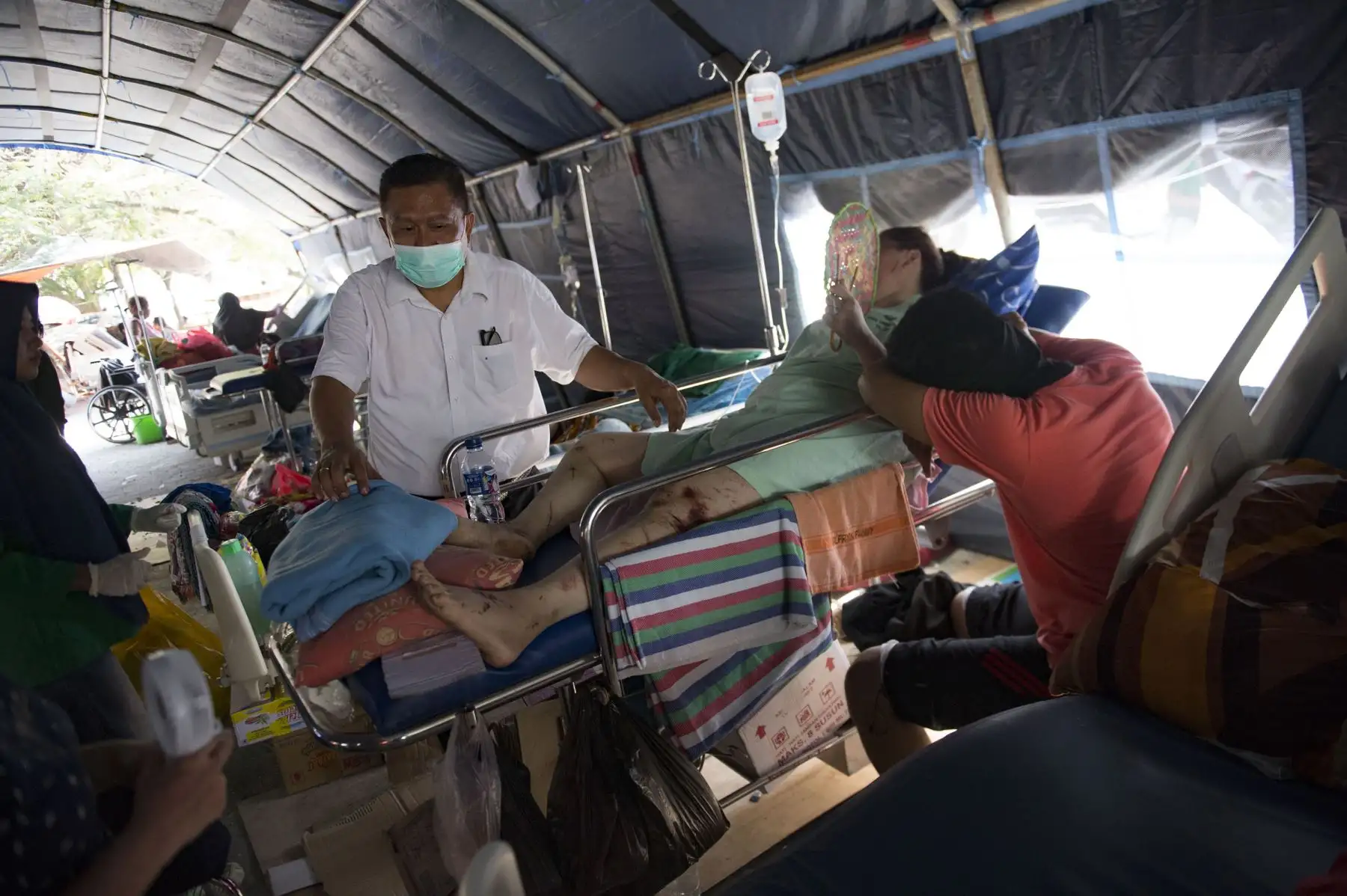 Un médico revisa a los sobrevivientes del tsunami en un pabellón temporal establecido en el hospital Undata en Palu, en Sulawesi Central, el 2 de octubre de 2018, cuatro días después de que un fuerte terremoto y un tsunami azotaron el área. AFP