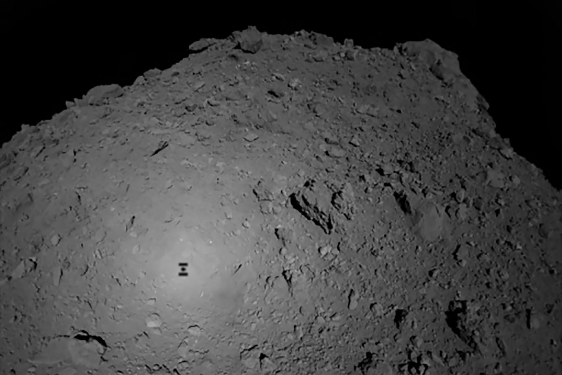 La Agencia de Exploración Aeroespacial (Jaxa) muestra la sombra de la nave espacial japonesa Hayabusa2 sobre el asteroide Ryugu. Foto: AFP.