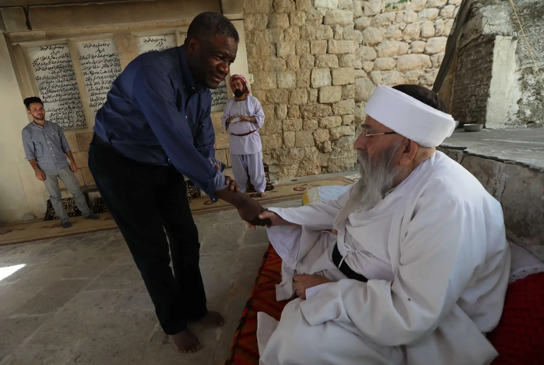 En esta foto de archivo tomada el 24 de junio de 2018, el ginecólogo congoleño Denis Mukwege le da la mano a Baba Sheikh Khurto Hajji Ismail en el corazón del templo de Lalish en un valle cerca de Dohuk, 430 km al noroeste de la capital iraquí de Bagdad. Foto: AFP