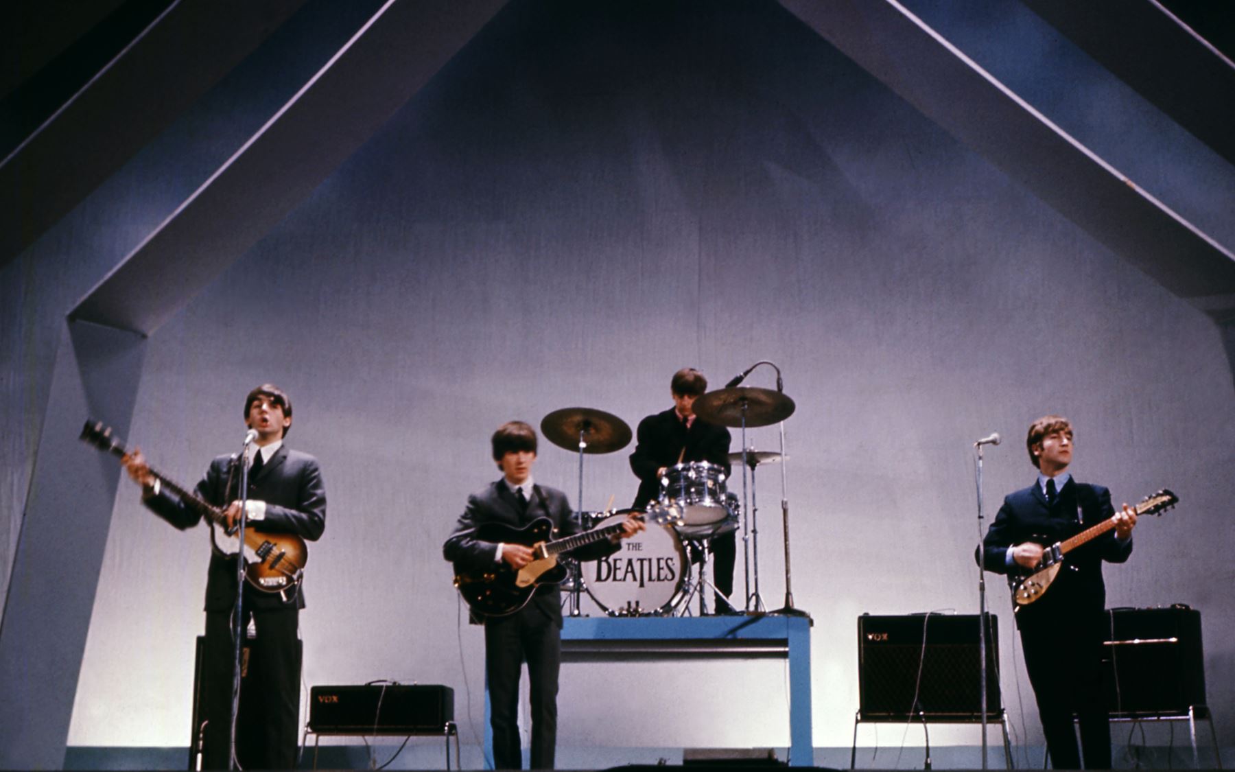 La banda inglesa The Beatles (de izquierda a derecha), Paul McCartney (bajo), George Harrison (guitarra), Ringo Starr (batería) y John Lennon (guitarra) se presentan en el escenario durante un concierto el 29 de julio de 1965 en Londres. / AFP