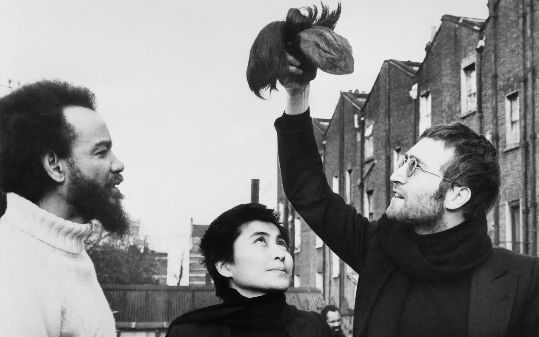 El cantante británico John Lennon (R), ex miembro de The Beatles y su esposa Yoko Ono, le entregan mechones de pelo al activista Michael de Freitas, también conocido como Michael X (L) el 13 de mayo de 1971 en Londres. AFP
