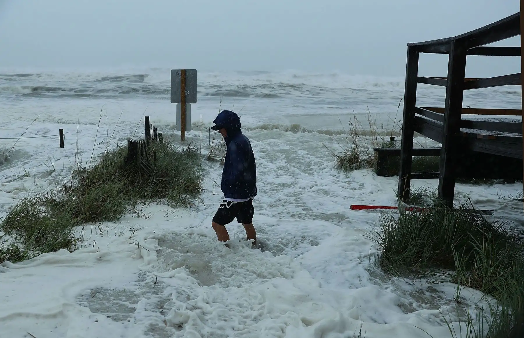 Cameron Sadowski camina a lo largo de donde las olas se estrellan en la playa cuando las bandas externas del huracán Michael llegan el 10 de octubre de 2018 a Panama City Beach, Florida. Se pronostica que el huracán azotará el Panhandle de Florida en una posible tormenta de categoría 4. AFP