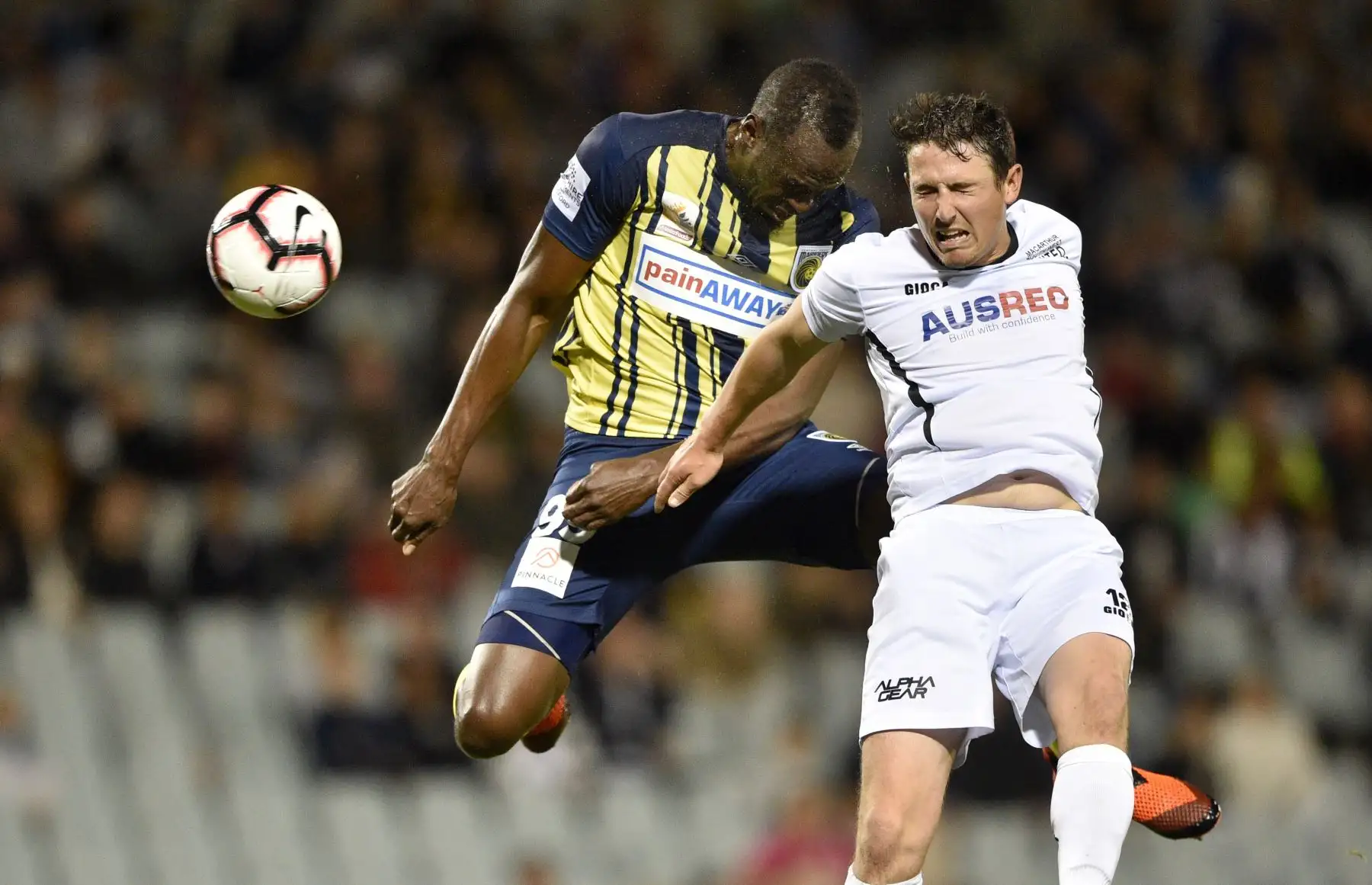 El velocista olímpico Usain Bolt (L) jugando para el club de fútbol A-League Central Coast Mariners desafía la pelota con Josh Symons de Macarthur South West United (R) en su primer inicio competitivo para el club en Sydney el 12 de octubre de 2018.  AFP