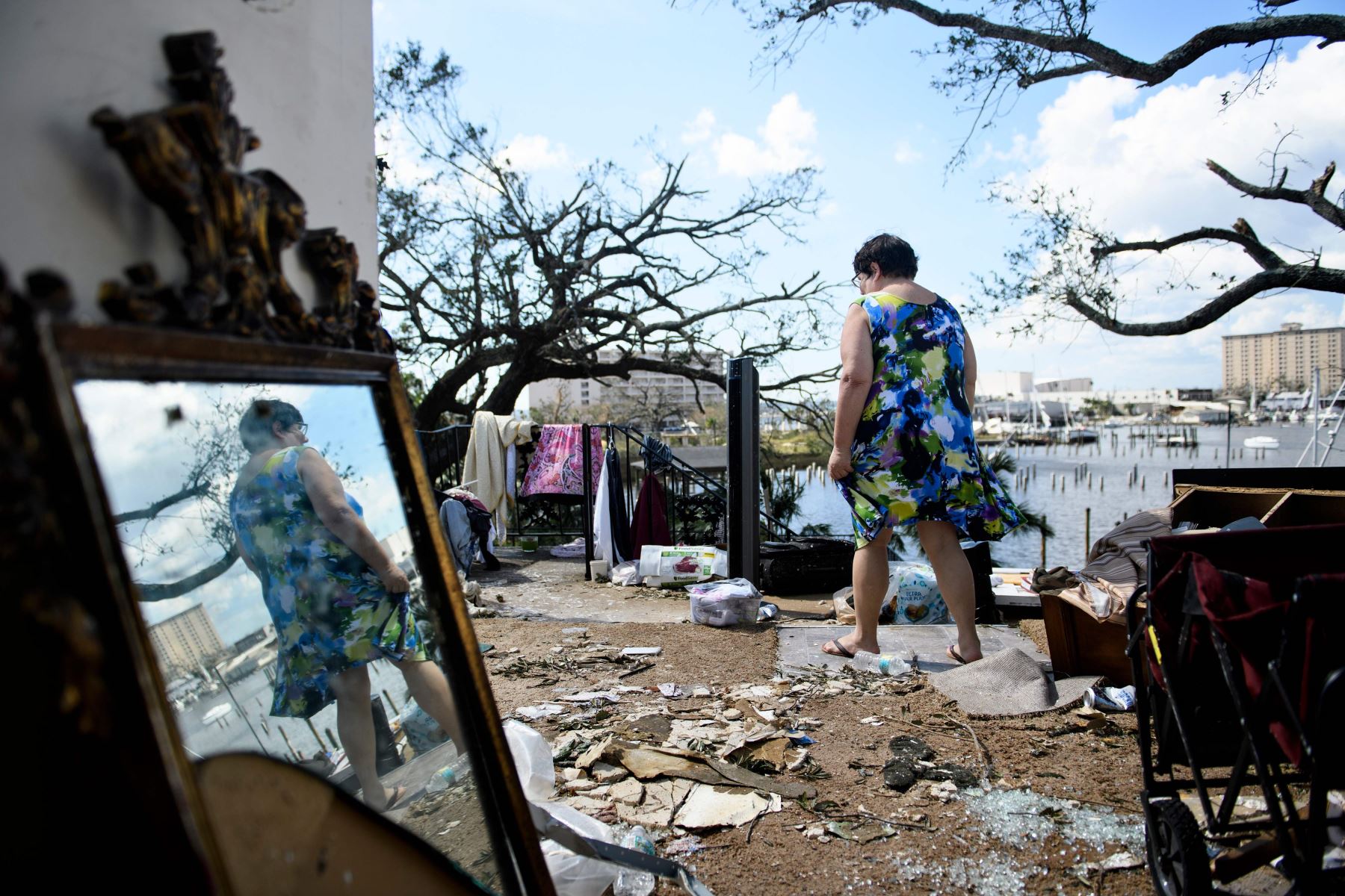 Teresa Sheffield sale de los restos de su apartamento en el segundo piso después del huracán Michael Foto: AFP
