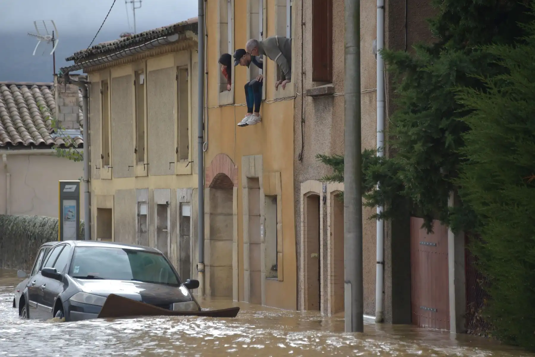 Los residentes miran desde su ventana sobre los autos que están parados en una calle inundada después de las fuertes lluvias que vieron cómo los ríos se desbordaban  en Trebes,  Francia. - Seis personas murieron luego de una tormenta e inundaciones repentinas dijeron las autoridades. AFP