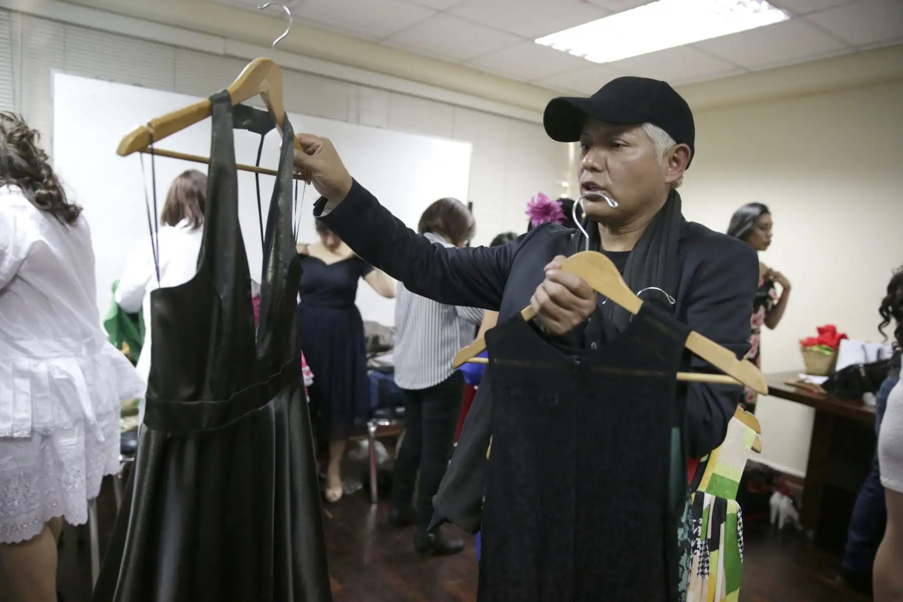 Diseñador de moda, Ciro Taipe entrega los vestidos a las participantes en el backstage del desfile "Siempre bellas" que organiza el INEN. Foto: ANDINA/Melina Mejía