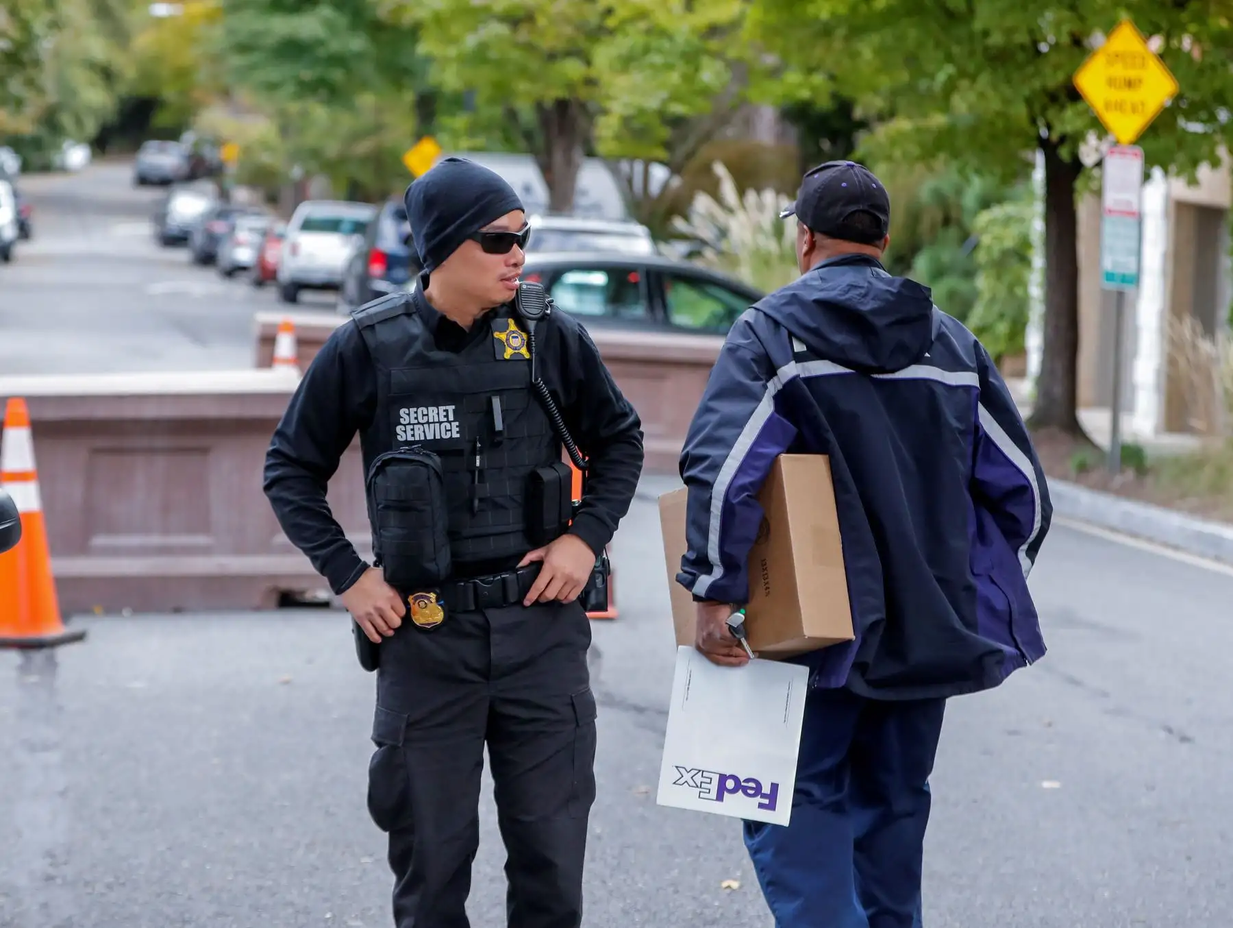 Un miembro del Servicio Secreto de los Estados Unidos (i) habla con un repartidor cerca de la residencia del expresidente estadounidense Barack Obama en Washington, Estados Unidos, hoy, 24 de octubre de 2018. Las autoridades estadounidenses encontraron artefactos explosivos en sendos sobres de correo dirigidos a la exsecretaria de Estado de Hillary Clinton en su oficina en Nueva York y a la residencia del expresidente Barack Obama en Washington. EFE