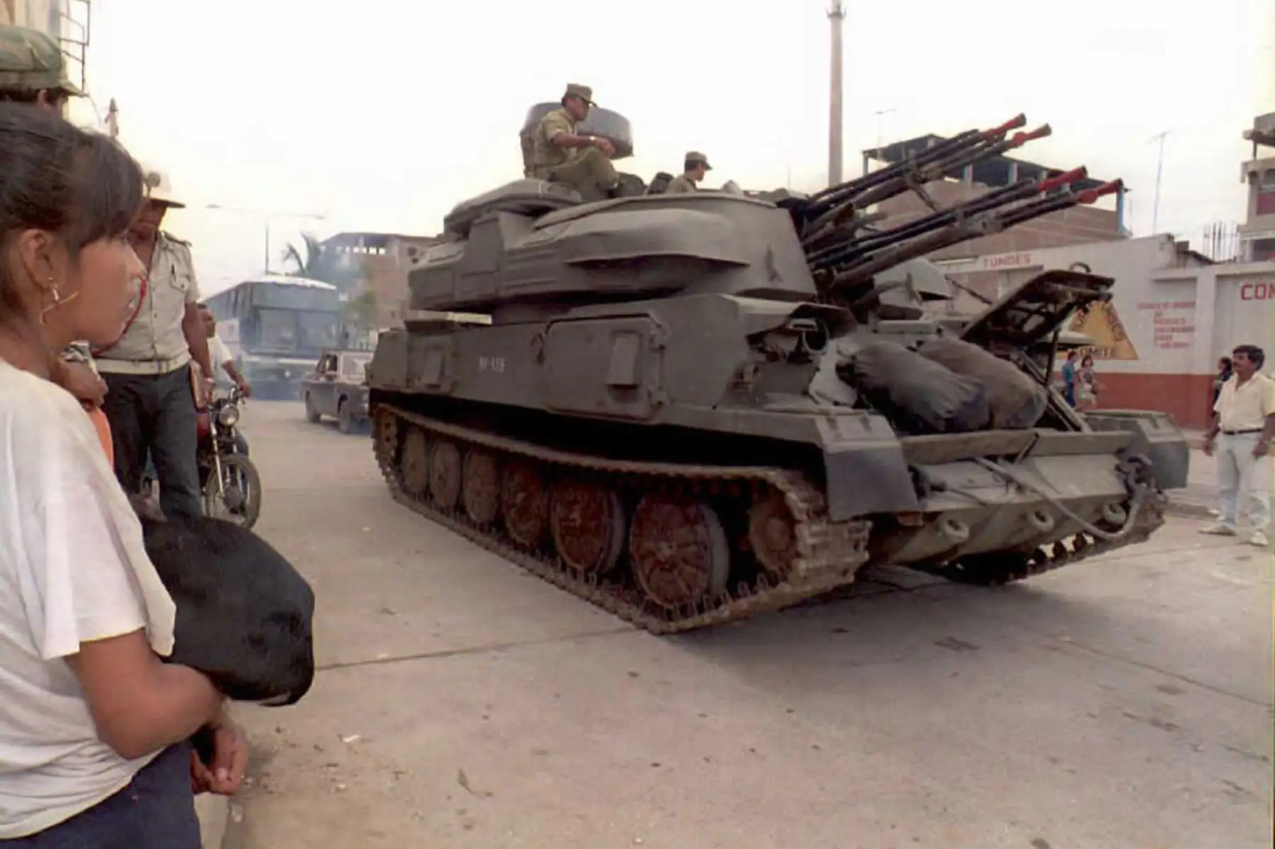 Los residentes locales observan cómo un vehículo blindado del Ejército Peruano rueda por la calle principal el 29 de enero de 1995 en Tumbes, Perú, cerca de la frontera con Ecuador.  Foto: AFP