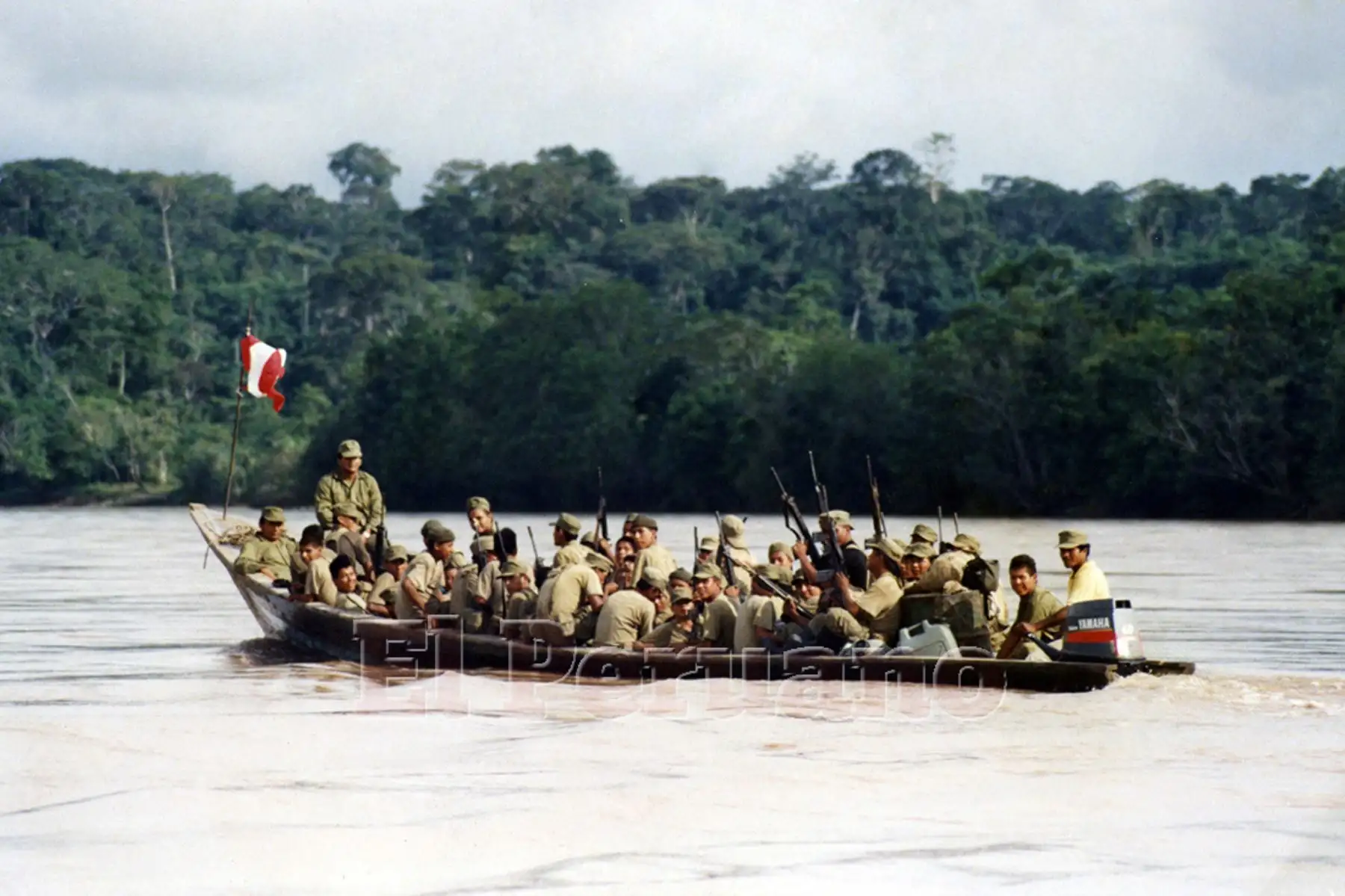 Un grupo de soldados del Ejército peruano alzan sus armas mientras son transportados por un río de la selva. Millares de soldados peruanos especializados en la lucha contra el terrorismo son enviados para reforzar las bases militares cerca de la frontera con Ecuador (1995). Foto: Archivo Histórico de EL PERUANO