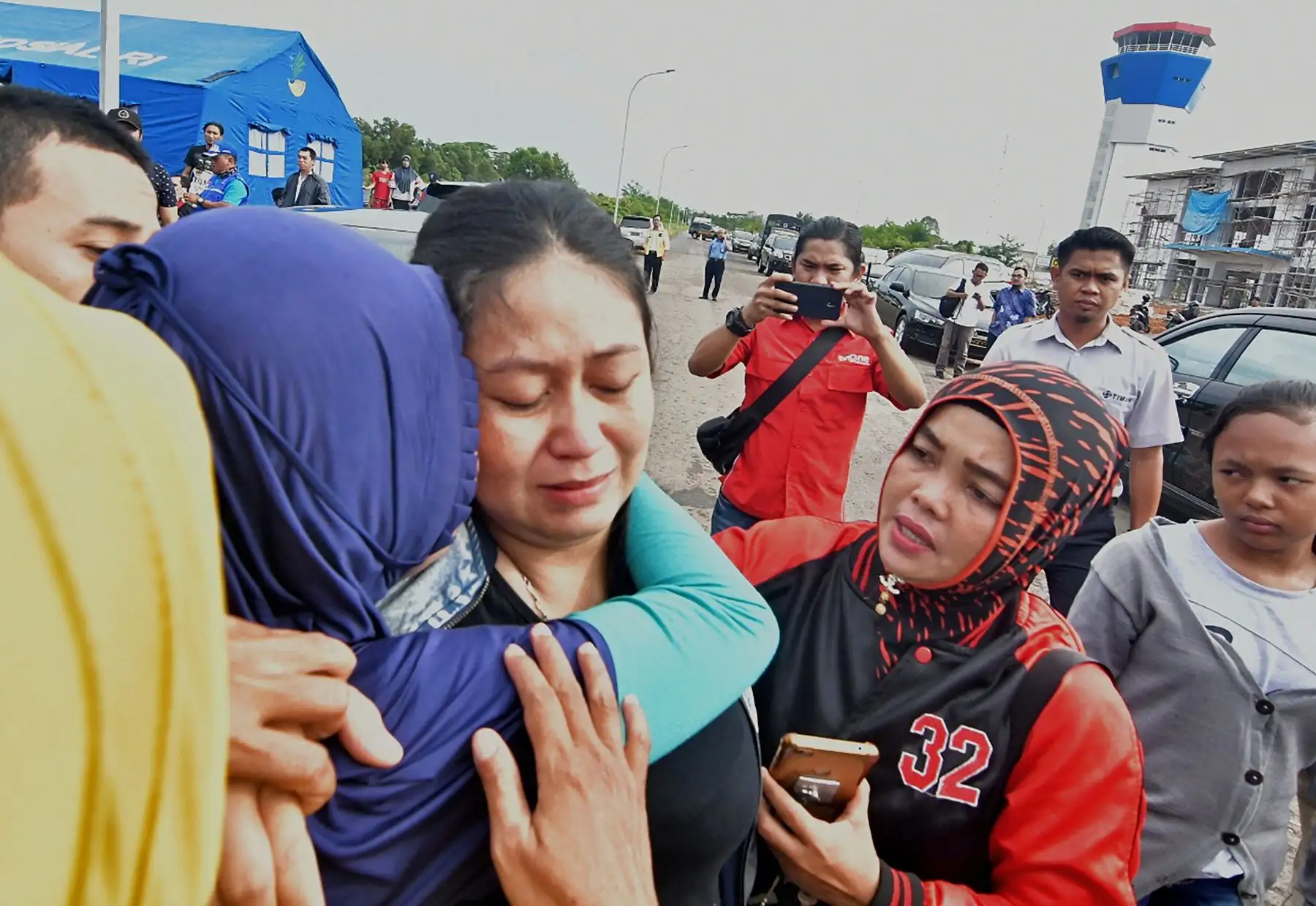Putri (C) es consolada por la pérdida de su esposo e hijo, que eran pasajeros a bordo del vuelo JT 610 de Lion Air, en el aeropuerto de Pangkal Pinang, en la provincia de Bangka Belitung, el 29 de octubre de 2018. Un avión que transportaba a 189 pasajeros y tripulantes se estrelló en el mar el 29 de octubre, dijeron las autoridades, momentos después de que solicitó que se le permitiera regresar a Yakarta. AFP