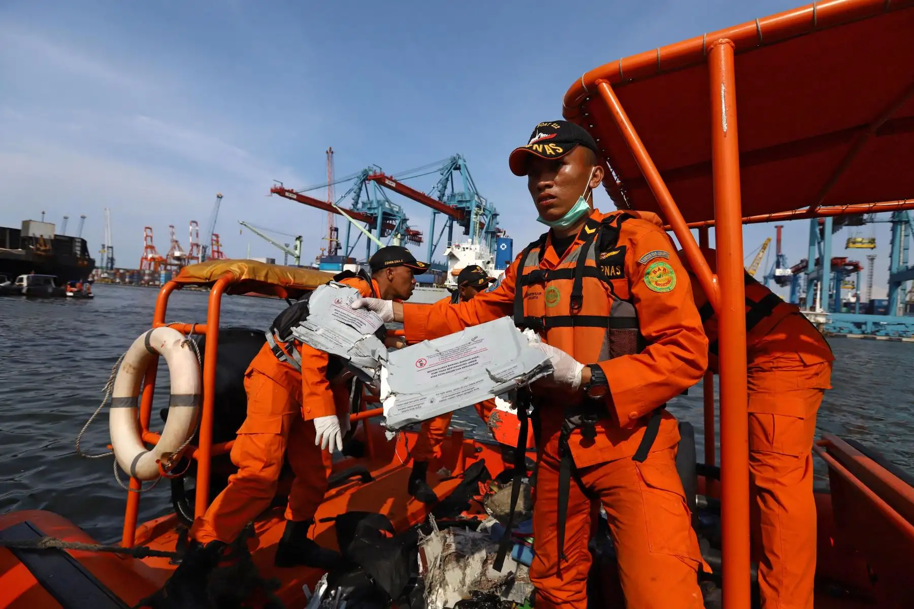 El 29 de octubre de 2018, miembros de un equipo de rescate traen a tierra artículos personales y restos en el puerto de Tanjung Priok, en el norte de Yakarta, después de que fueron recuperados del mar donde el vuelo JT 610 de Lion Air se estrelló frente a la costa norte. - Un nuevo avión indonesio Lion Air que transportaba a 189 pasajeros y tripulantes se estrelló en el mar el 29 de octubre, dijeron las autoridades, momentos después de haber solicitado que se le permitiera regresar a Yakarta. AFP