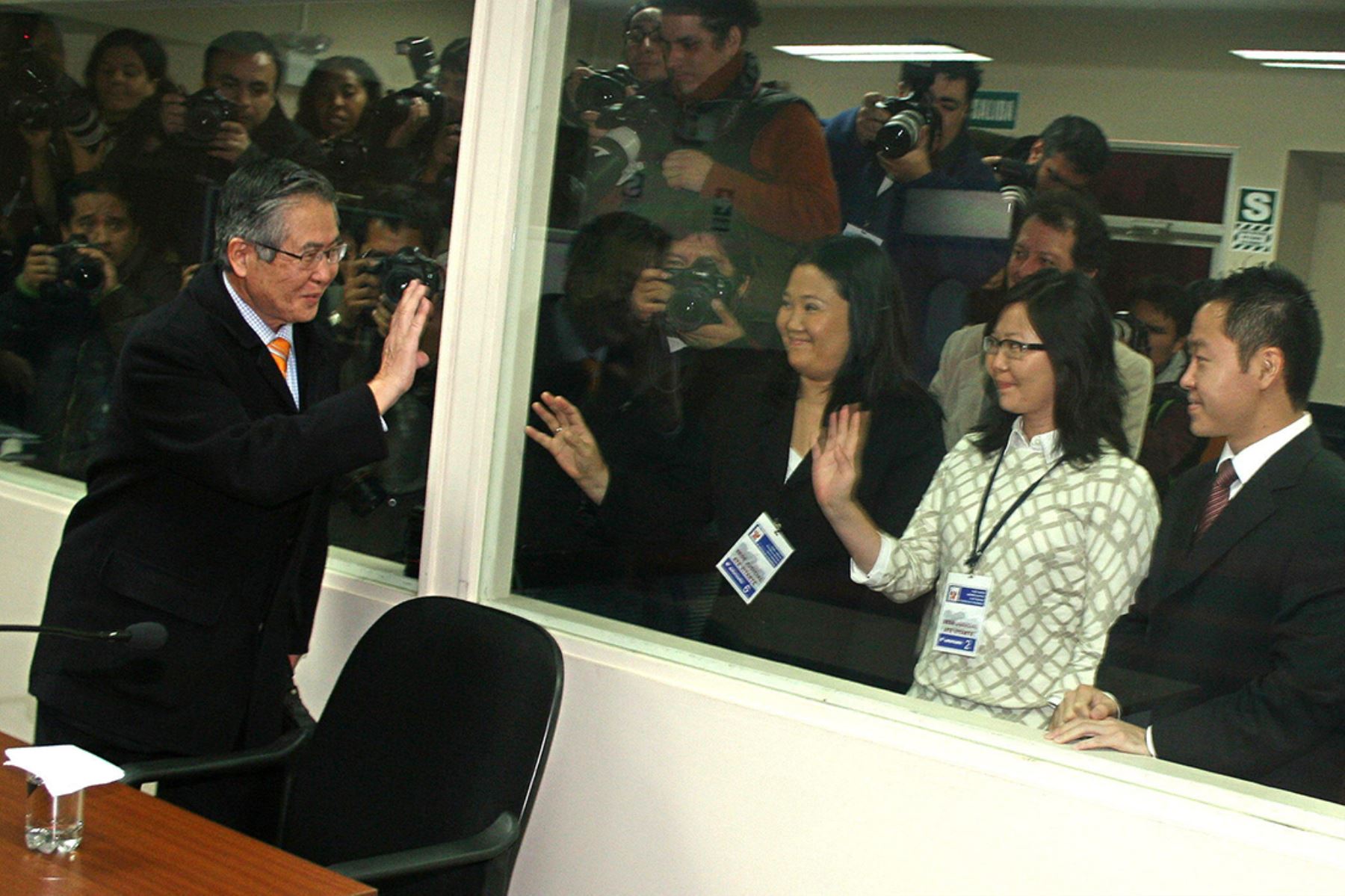 El ex presidente peruano Alberto Fujimori  saluda a sus hijos Keiko, Sachi y Kenji el 30 de junio de 2008, en la sala en donde se le juzga, instalada en la sede de la Dirección de Operaciones Especiales de la Policía (Diroes). Foto: Poder Judicial