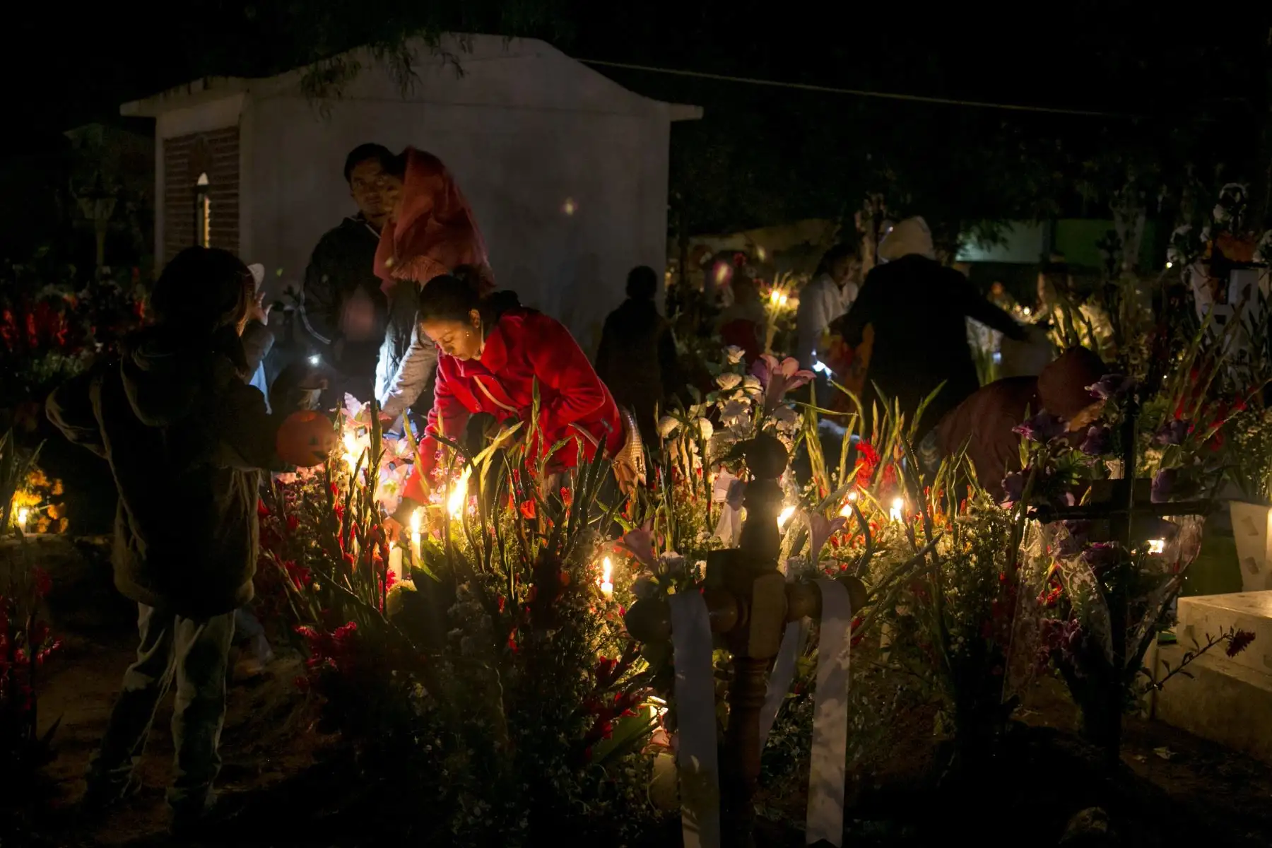 Pobladores del municipio de Xochitl, en el estado de Puebla (México), velan a sus muertos en el panteón de la localidad hoy, viernes 2 de noviembre de 2018. La tradición de los altares de muertos se remonta a la fusión, hace unos 500 años, de tradiciones traídas por los misioneros franciscanos y las de las diversas culturas que habitaron en el territorio mexicano como la Olmeca, Zapoteca, Mixteca, Purepecha, Maya, Totonaca y Azteca. Los mexicanos adem·s de visitar las tumbas de sus seres queridos, instalan