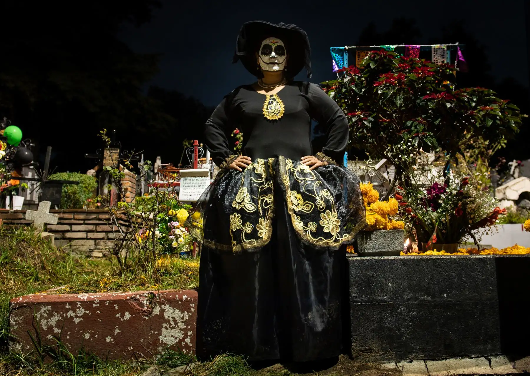 Marta Cecilia Olivares, vestida como "Catrina" (representación mexicana de la muerte), posa junto a tumbas en el cementerio de San Francisco en la Ciudad de México . - Los mexicanos visitan los cementerios en el Día de Todos los Santos para conmemorar el Día de Muertos.