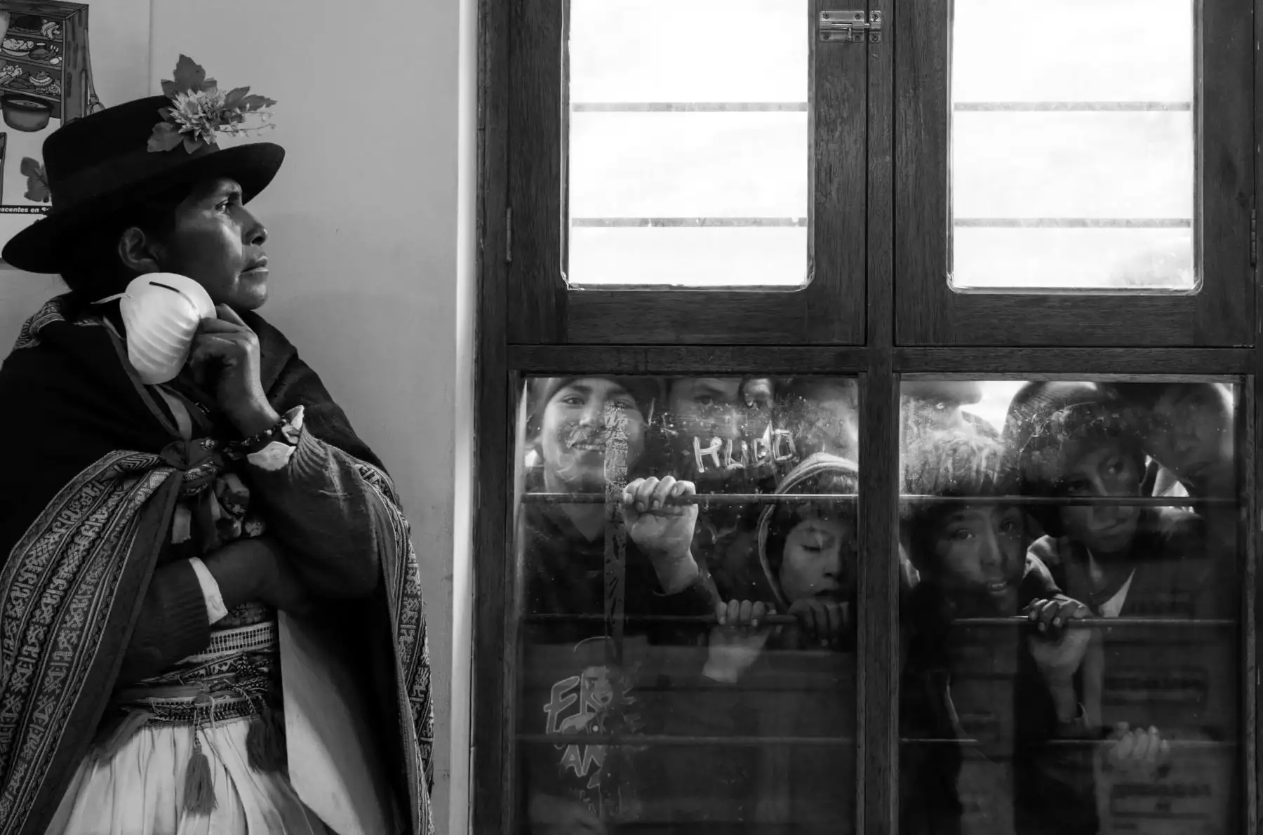 Una pobladora de Llaccua (Ayacucho) espera en el frío pasillo de la posta medica la entrega de los restos de su familiar. A través de la ventana, la curiosidad de los niños se asoma. Foto: ANDINA/Jack Ramón