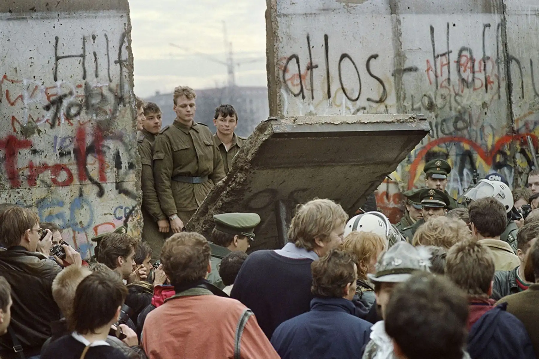 Los berlineses occidentales se agolpan frente al Muro de Berlín a principios del 11 de noviembre de 1989 mientras  los guardias fronterizos de Alemania Oriental ven caer parte del muro cerca a la Plaza Potsdamer. Dos días antes, Gunther Schabowski,  portavoz del Partido Comunista de la RDA , declaró que  los alemanes orientales serían libres de abandonar el país, sin permiso, en cualquier punto a lo largo de la frontera, incluidos los puntos de cruce a través del Muro en Berlín. Foto: AFP