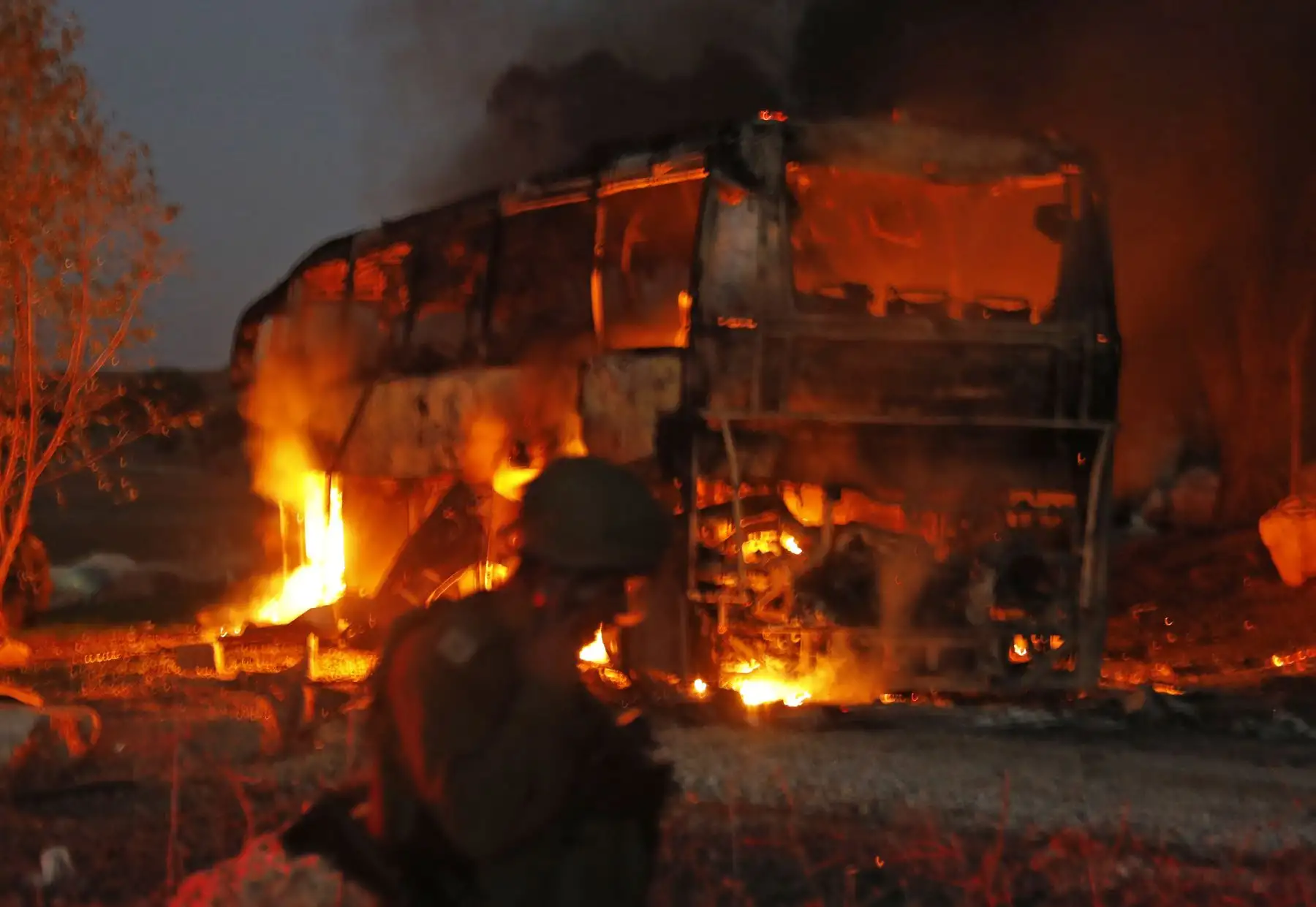 Las fuerzas de seguridad y los bomberos israelíes se reúnen cerca de un autobús incendiado después de que un cohete disparó desde el enclave palestino, en la frontera entre Israel y Gaza, cerca del kibbutz de Kfar Aza. - El ejército de Israel dijo que llevaba los ataques aéreos "a lo largo de la Franja de Gaza" después del lanzamiento de cohetes desde el enclave palestino hacia su territorio.  AFP