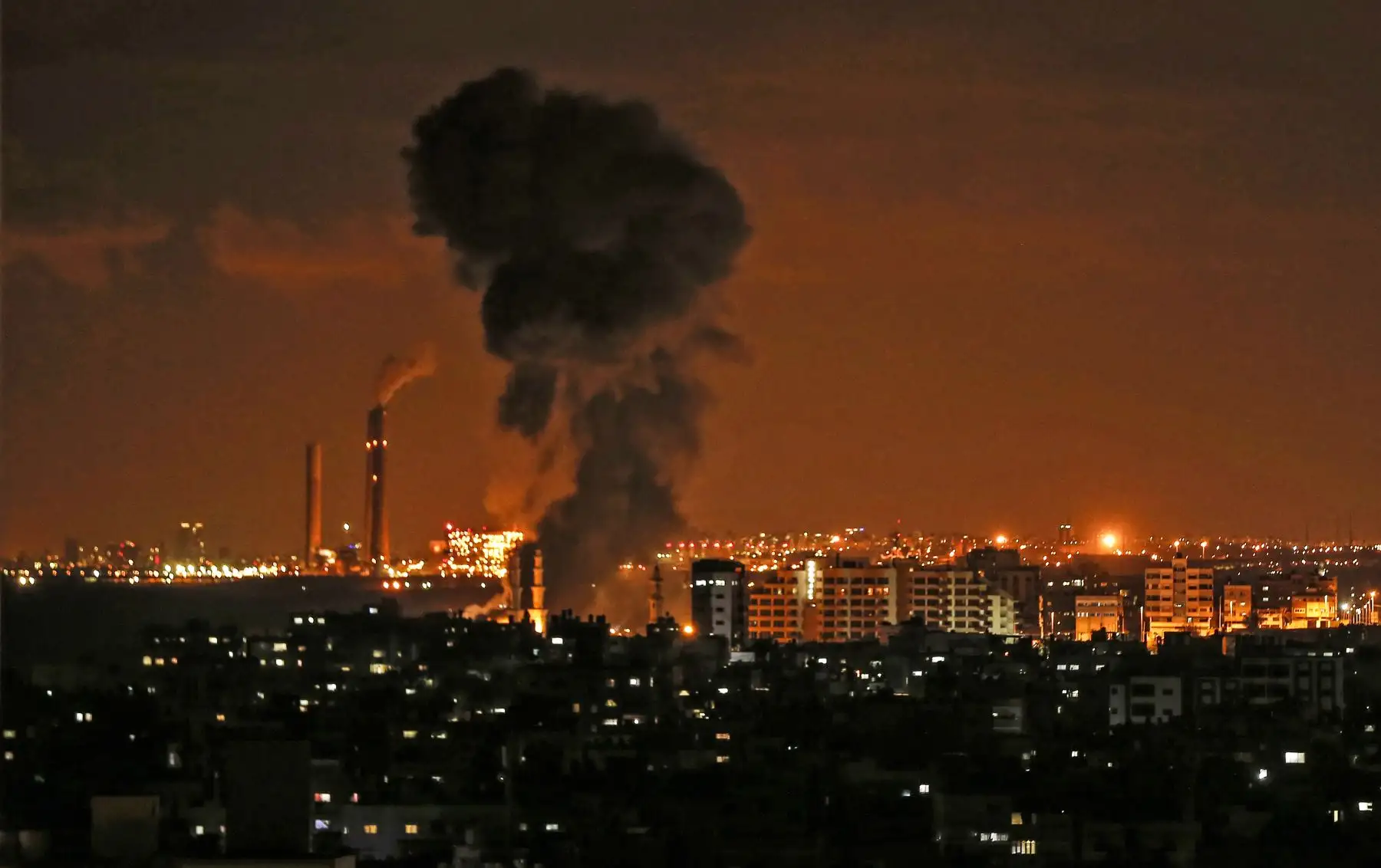 Una fotografía tomada desde la ciudad de Gaza, muestra humo saliendo en la distancia durante ataques aéreos israelíes en el enclave palestino manejado por Hamas. - Los ataques aéreos israelíes apuntaron a la Franja de Gaza después de un ataque de cohetes hacia su territorio desde el enclave, ya que la violencia renovada amenazaba con descarrilar los esfuerzos para restablecer la calma.  AFP