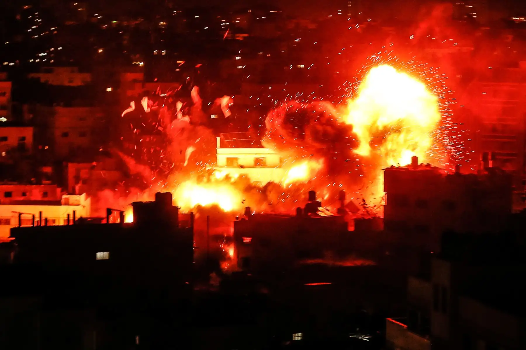 Una fotografía muestra una bola de fuego sobre el edificio que alberga la estación de televisión de Al-Aqsa de Hamas en la Franja de Gaza durante un ataque aéreo israelí. - Los ataques aéreos israelíes en Gaza mataron a tres palestinos y destruyeron un edificio de Hamas TV el 12 de noviembre después de un bombardeo de cohetes desde el enclave, ya que la violencia renovada amenazaba con descarrilar los esfuerzos para poner fin a meses de disturbios. AFP
