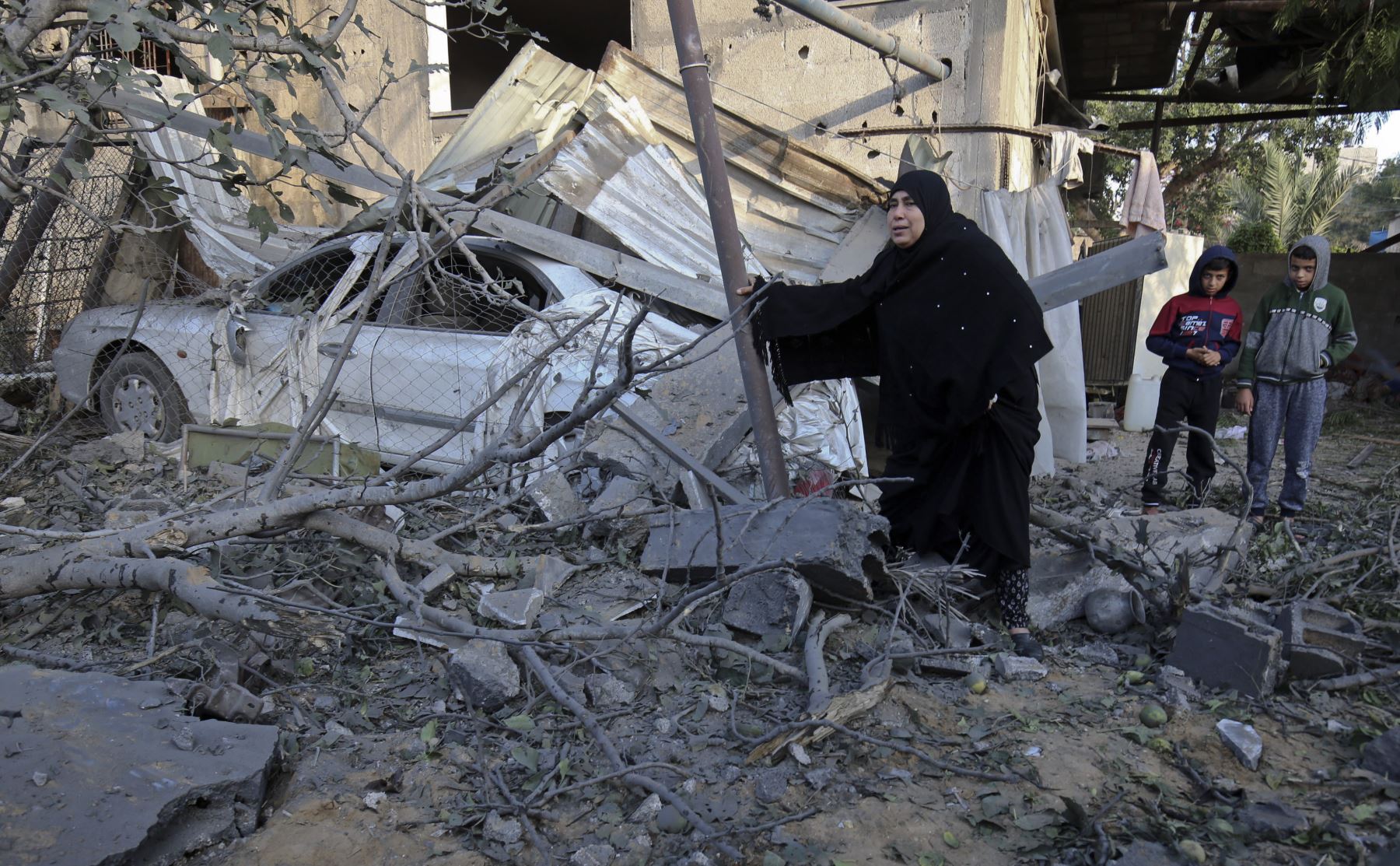 Palestinos caminan en medio de escombros de un edificio residencial que fue destruido en un ataque aéreo israelí en Khan Yunis en el sur de la Franja de Gaza el 13 de noviembre de 2018. - El avión de Israel impactó en Gaza el 12 de noviembre, después de una descarga de cohetes desde su territorio. enclave. El estallido se produjo después de una operación letal de las fuerzas especiales israelíes en la Franja de Gaza el fin de semana que dejó a Hamas jurando venganza.  AFP