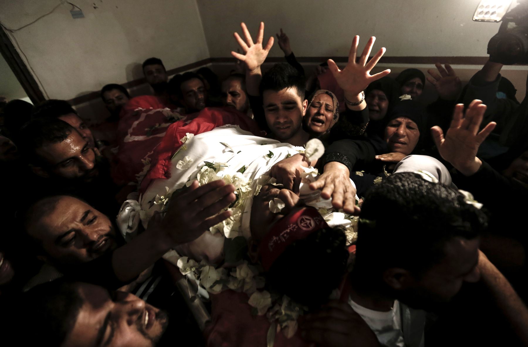 Los familiares de Mohammed Ouda, muertos en un ataque aéreo israelí el día anterior, arrojaron flores sobre su cuerpo durante su funeral en Beit Lahia, en el norte de la Franja de Gaza, el 13 de noviembre de 2018. - Seis muertos de palestinos en Gaza en menos de 24 horas. Los ataques israelíes atacaron a los militantes y allanaron los edificios mientras enviaban bolas de fuego y columnas de humo al cielo en la peor escalada entre Israel y los militantes palestinos en Gaza desde la guerra de 2014. AFP