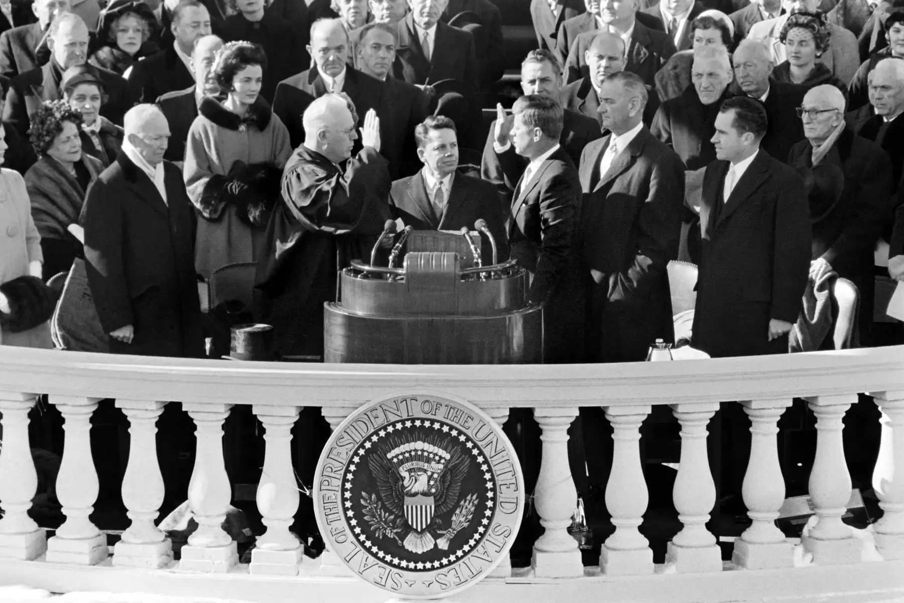 John Fitzgerald Kennedy (R) es juramentado como el 35 ° presidente de los EE. UU. Por el Juez Supremo del Tribunal Supremo, Earl Warren (L), frente al Capitolio en Washington el 20 de enero de 1961. Asisten, en la primera fila, el ex presidente de los EE. UU. Dwight D Eisenhower (L), el vicepresidente de los Estados Unidos Lyndon Johnson (2ª R) y el ex vicepresidente de los Estados Unidos, Richard Nixon (R). AFP