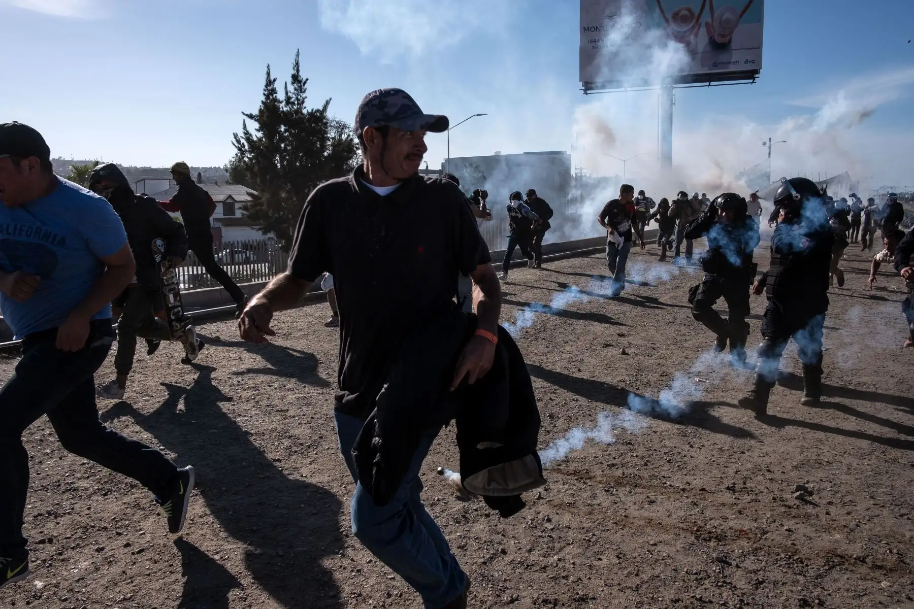 Los migrantes centroamericanos, en su mayoría hondureños, corren a lo largo del río Tijuana cerca del cruce fronterizo de El Chaparral en Tijuana, estado de Baja California, México, cerca de la frontera entre EE. UU. Y México, después de que la patrulla fronteriza de EE. UU. Arrojara gas lacrimógeno desde la distancia para dispersarlos después de un supuesto disputa verbal. Las autoridades estadounidenses cerraron el cruce de San Ysidro en el sur de California el domingo después de que cientos de migrantes,