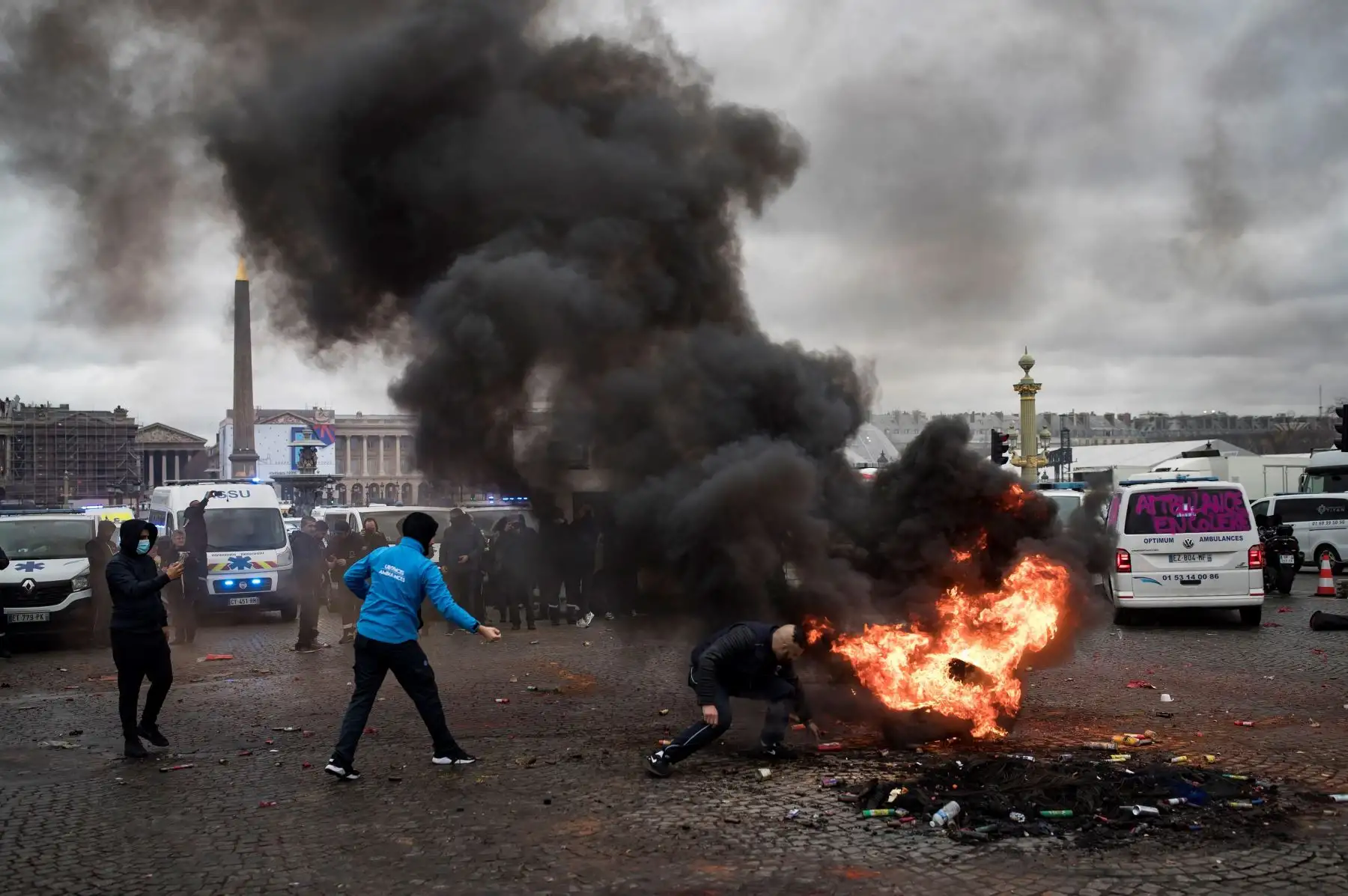 Conductores de ambulancias inician un fuego en la plaza de la Concorde mientras participan en una protesta ante la Asamblea Nacional, en ParÌs, Francia. Los manifestantes bloquearon el tráfico junto a la Asamblea Nacional para exigir la suspensión de una reforma del sistema de financiación de los transportes sanitarios. EFE