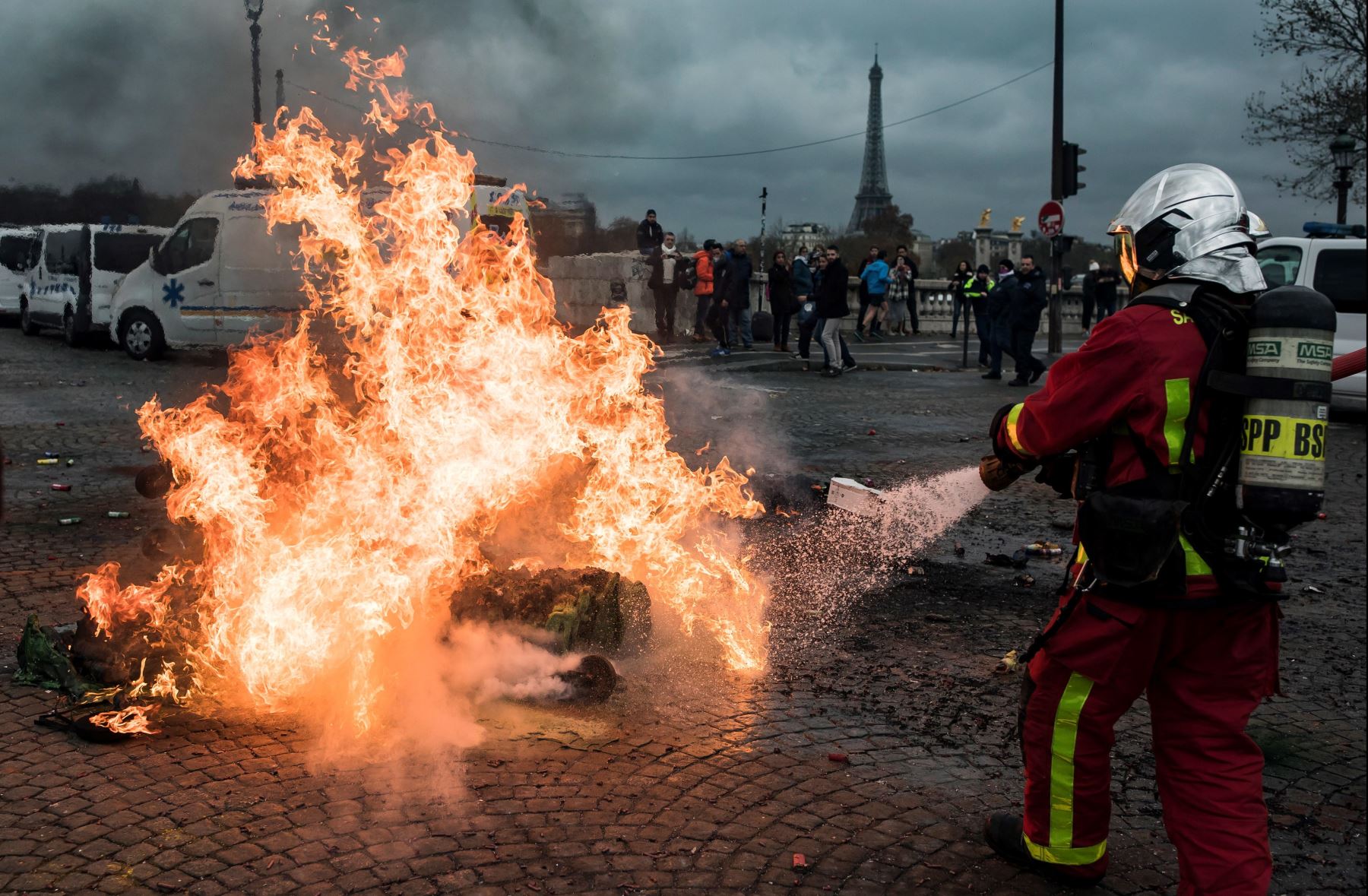 Bomberos apagan un fuego iniciado por conductores de ambulancias que participan en una protesta ante la Asamblea Nacional, en ParÌs, Francia. Los manifestantes bloquearon el tráfico junto a la Asamblea Nacional para exigir la suspensión de una reforma del sistema de financiación de los transportes sanitarios. EFE
