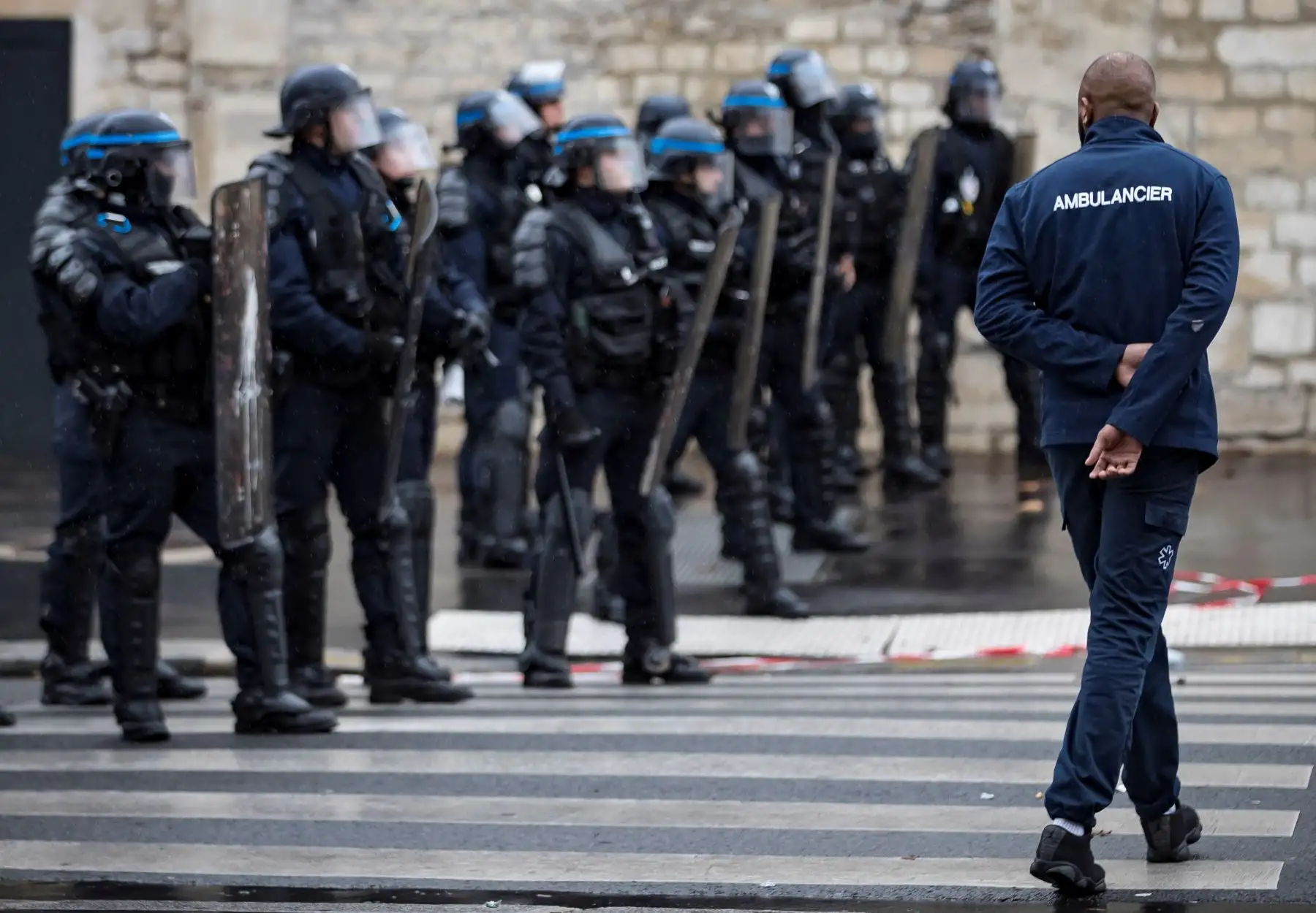 Un conductor de ambulancias camina ante un grupo de policías antidisturbios durante una protesta ante la Asamblea Nacional, en ParÌs, Francia. Los manifestantes bloquearon el tráfico junto a la Asamblea Nacional para exigir la suspensión de una reforma del sistema de financiación de los transportes sanitarios. EFE