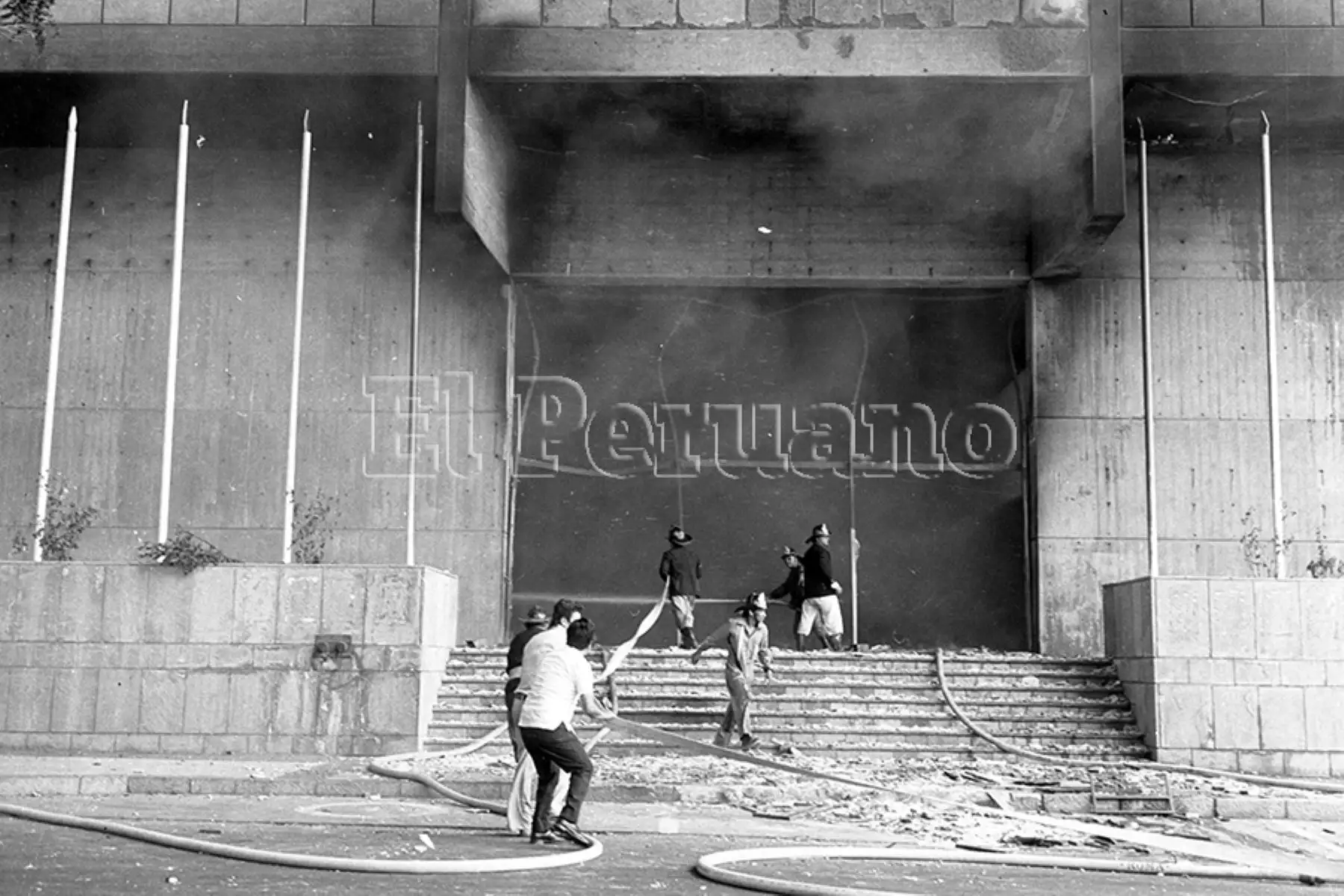 Lima - 5 febrero 1975 / Bomberos voluntarios intentan apagar el incendio en el Centro Cívico de Lima. La turbas que aprovecharon el paro policial atacaron también la sede de los diarios Ojo y Correo. Foto: Archivo Histórico de EL PERUANO